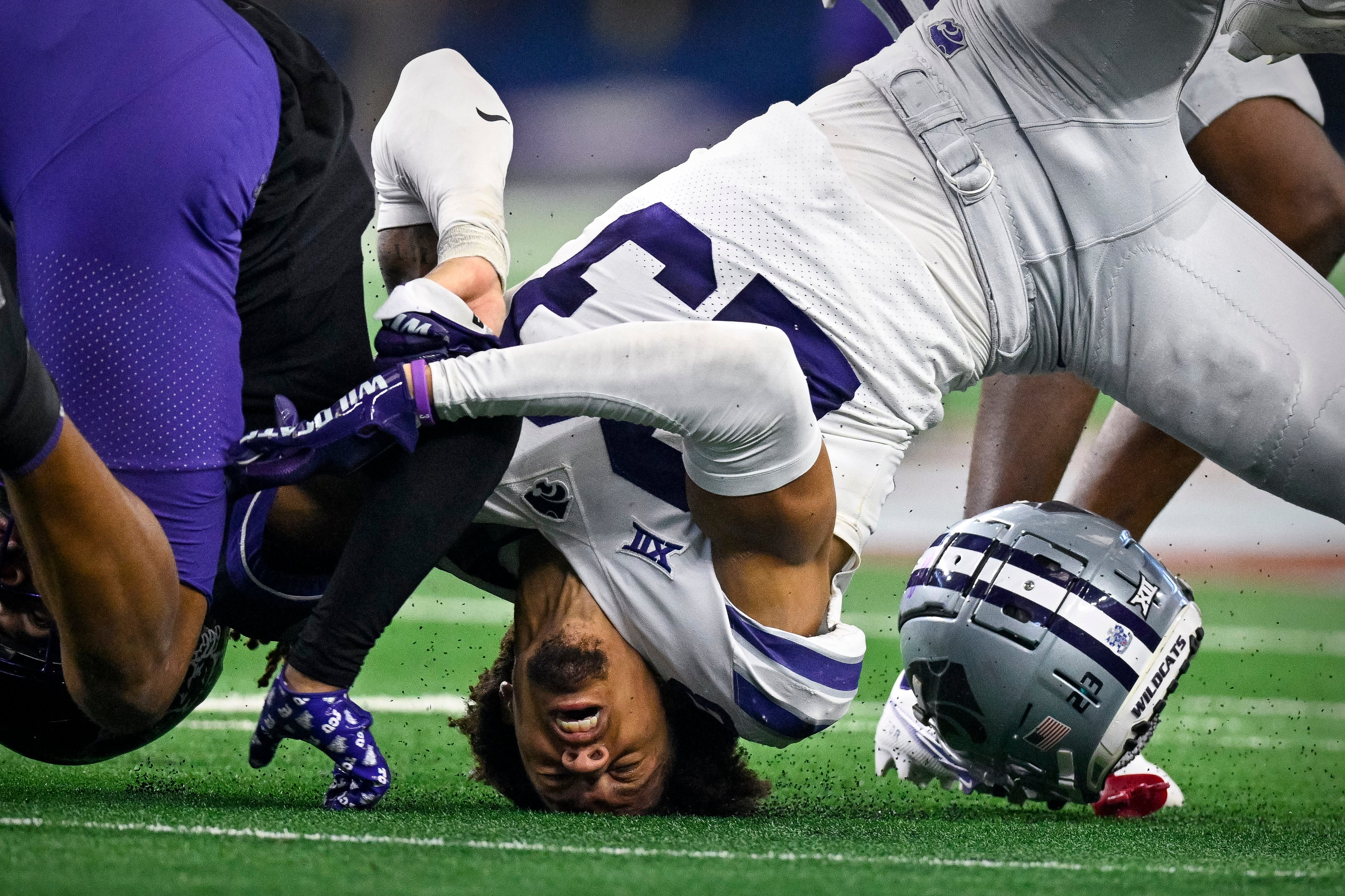 Dec 3, 2022; Arlington, TX, USA; Kansas State Wildcats cornerback Julius Brents (23) loses his helmet as he tackles TCU Horned Frogs wide receiver Quentin Johnston (1) at AT&T Stadium.