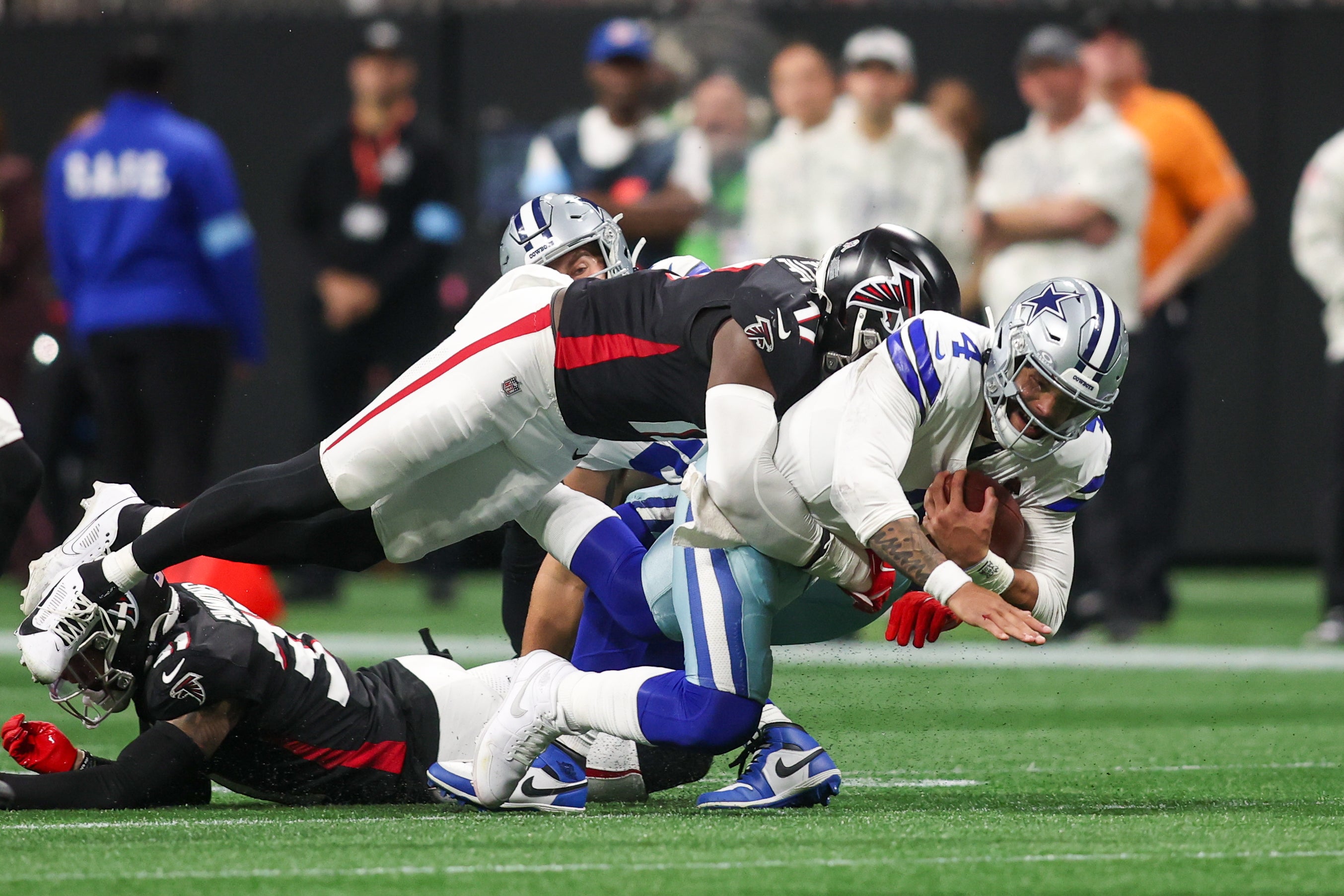 Atlanta Falcons linebacker Arnold Ebiketie (17) tackles Dallas Cowboys quarterback Dak Prescott (4) in the third quarter at Mercedes-Benz Stadium.