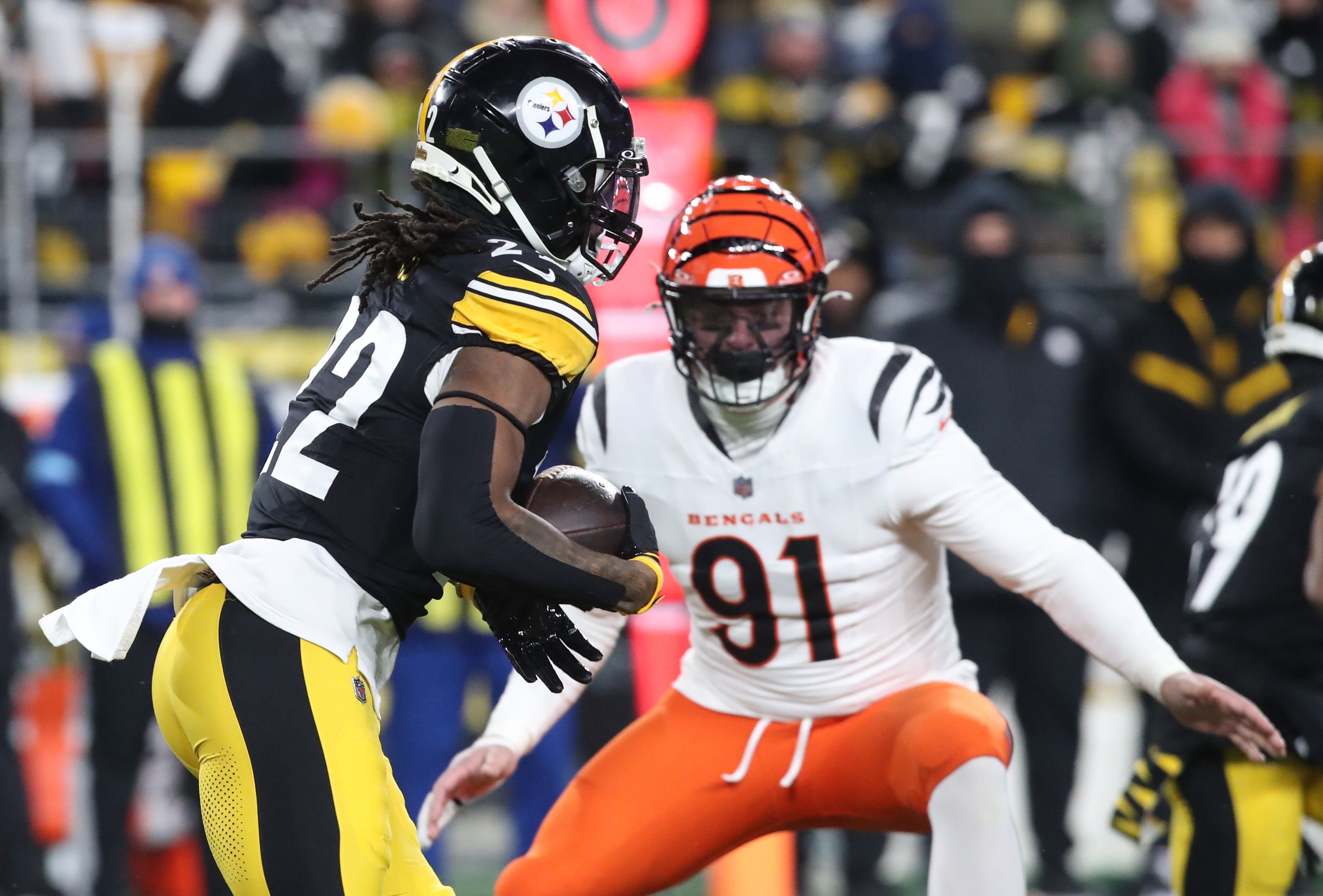 Jan 4, 2025; Pittsburgh, Pennsylvania, USA; Pittsburgh Steelers running back Najee Harris (22) runs the ball as Cincinnati Bengals defensive end Trey Hendrickson (91) defends during the first quarter at Acrisure Stadium.