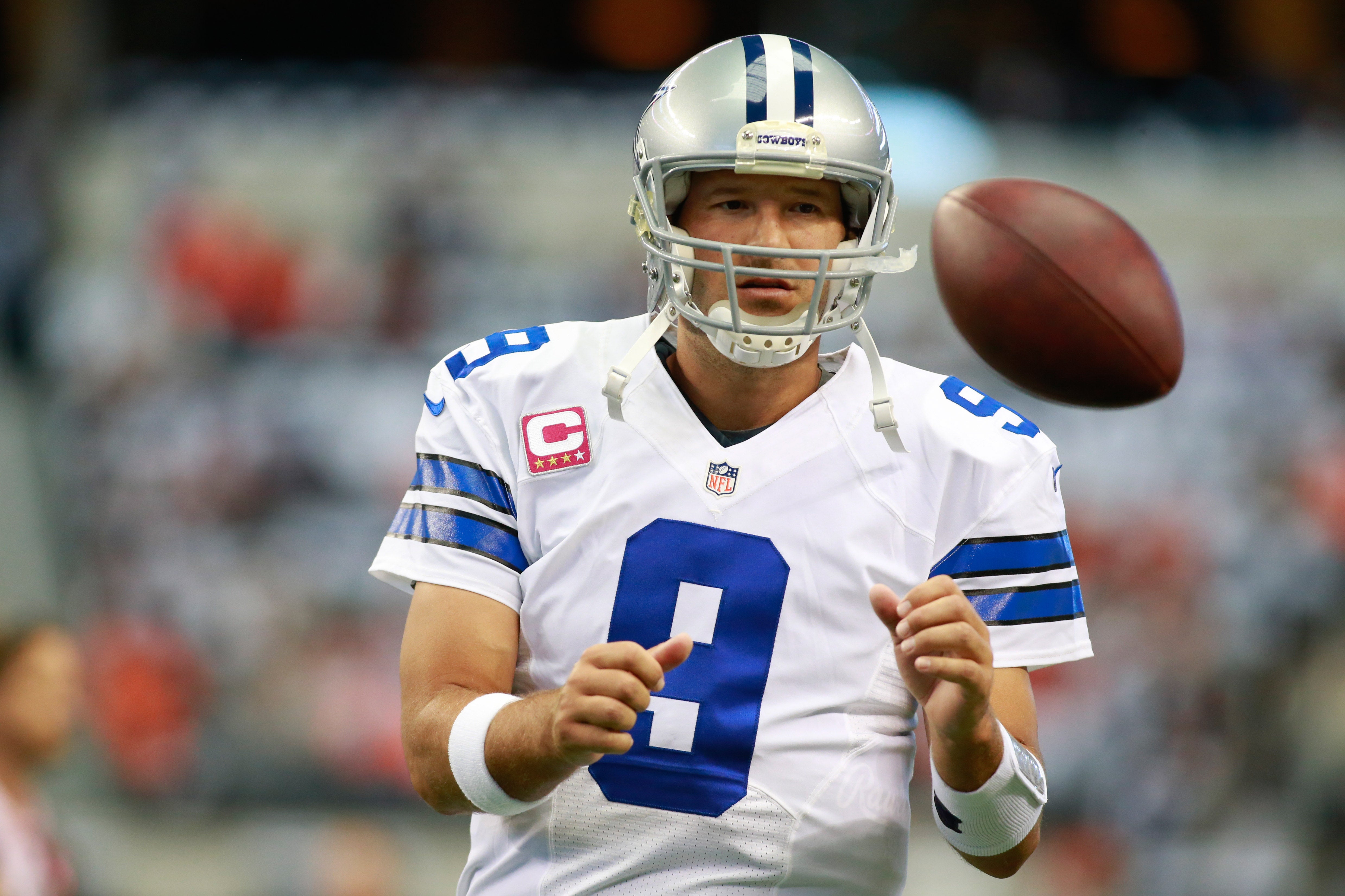 Dallas Cowboys quarterback Tony Romo (9) catches a ball during warmups before the game Denver Broncos at AT&T Stadium.