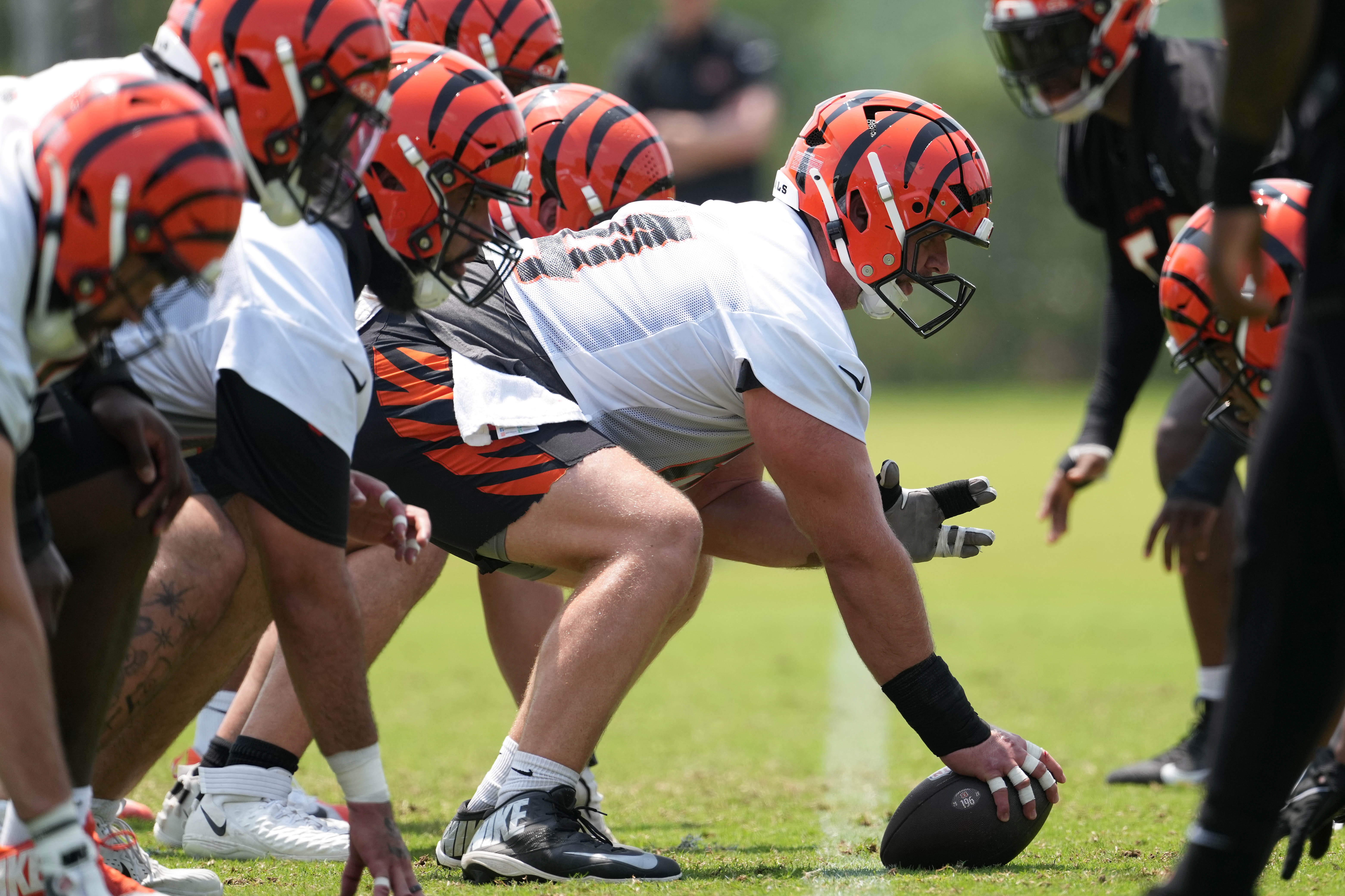 Jun 10, 2025; Cincinnati, OH, USA; Cincinnati Bengals center Ted Karras (64) (center) lines up with the offensive line at the line of scrimmage against the defensive line during practice at Paycor Stadium. 
