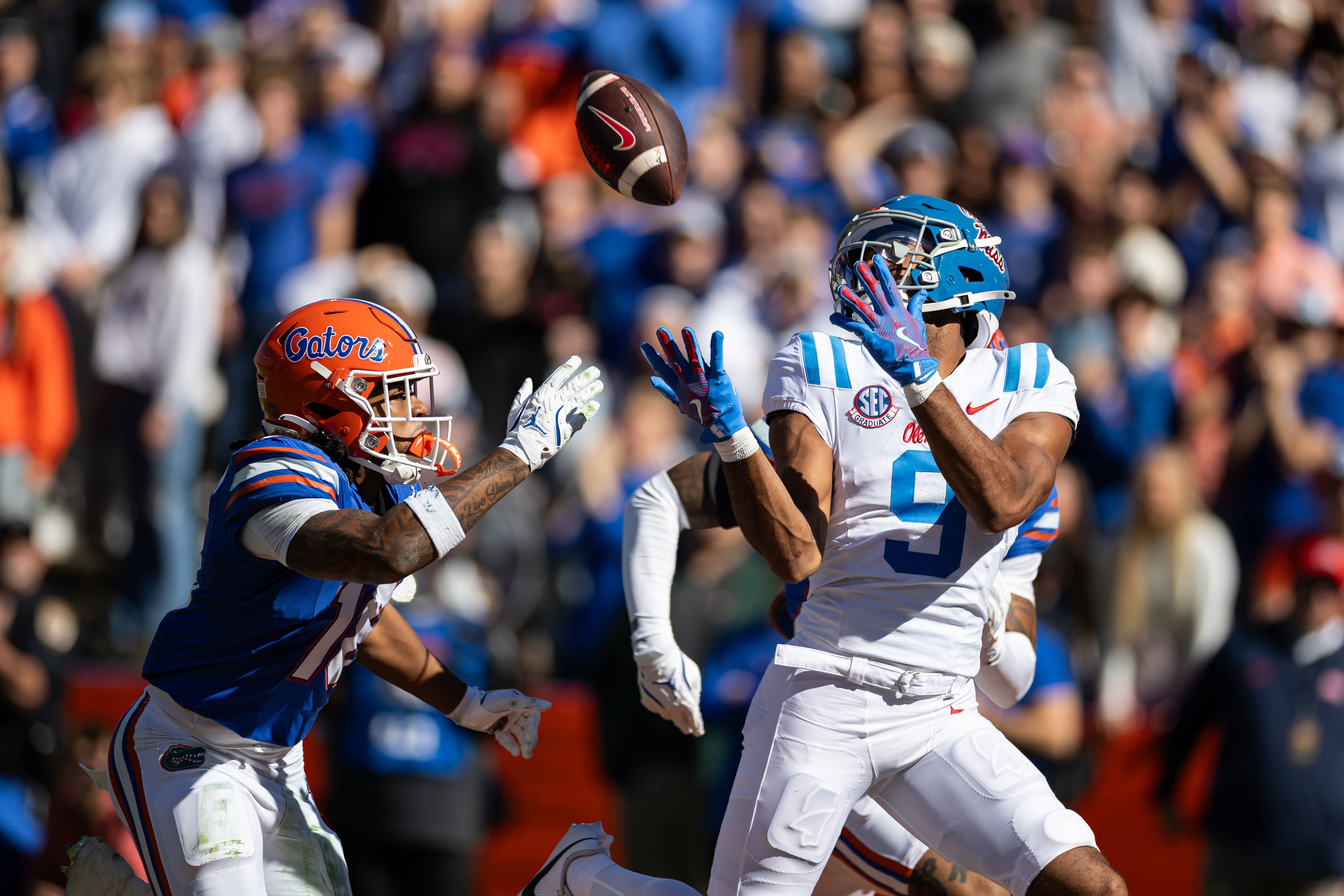Nov 23, 2024; Gainesville, Florida, USA; Mississippi Rebels wide receiver Tre Harris (9) makes a catch for a touchdown over Florida Gators defensive back Bryce Thornton (18) during the first half at Ben Hill Griffin Stadium.