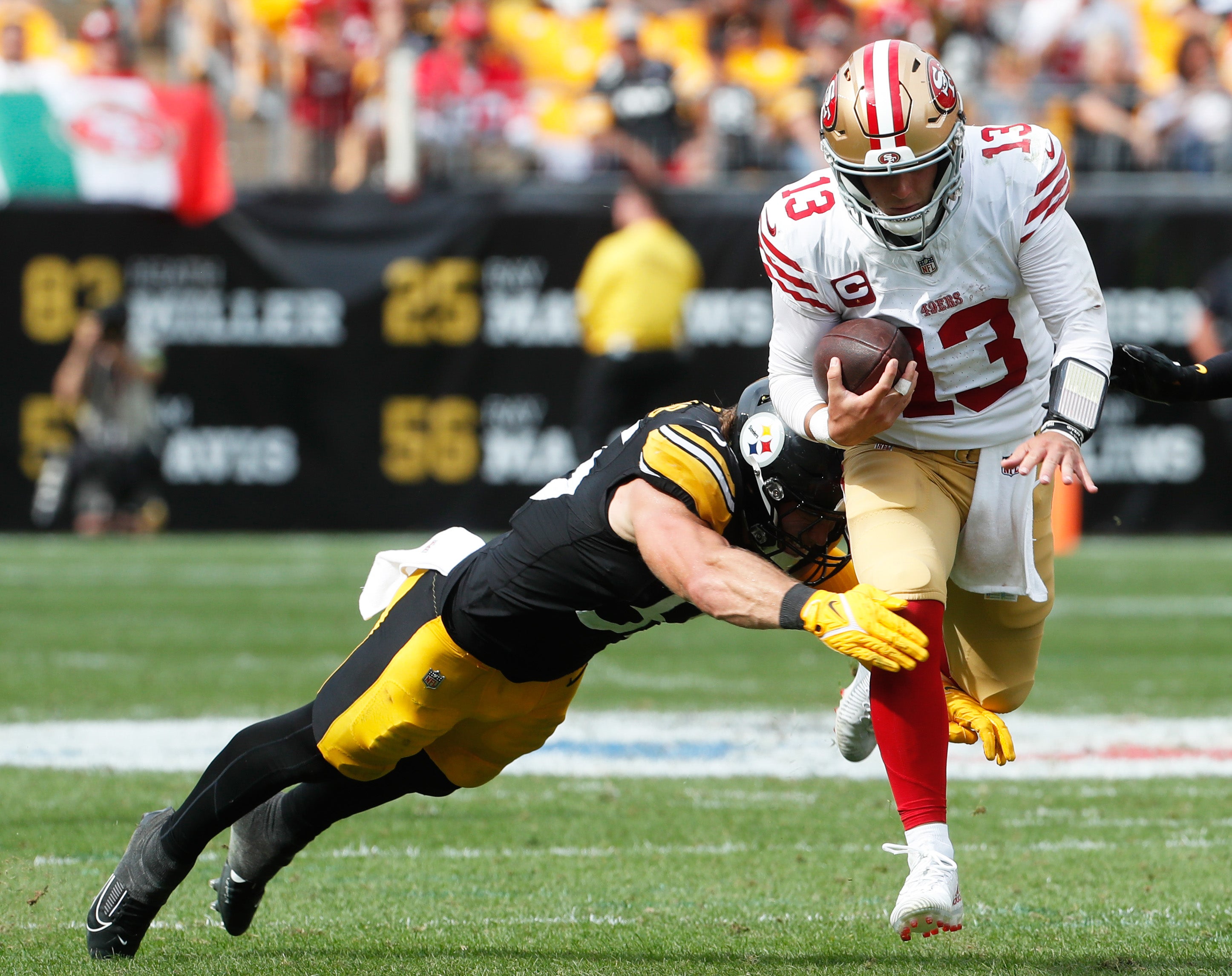 Sep 10, 2023; Pittsburgh, Pennsylvania, USA; San Francisco 49ers quarterback Brock Purdy (13) runs with the ball against Pittsburgh Steelers linebacker Cole Holcomb (55) during the fourth quarter at Acrisure Stadium.