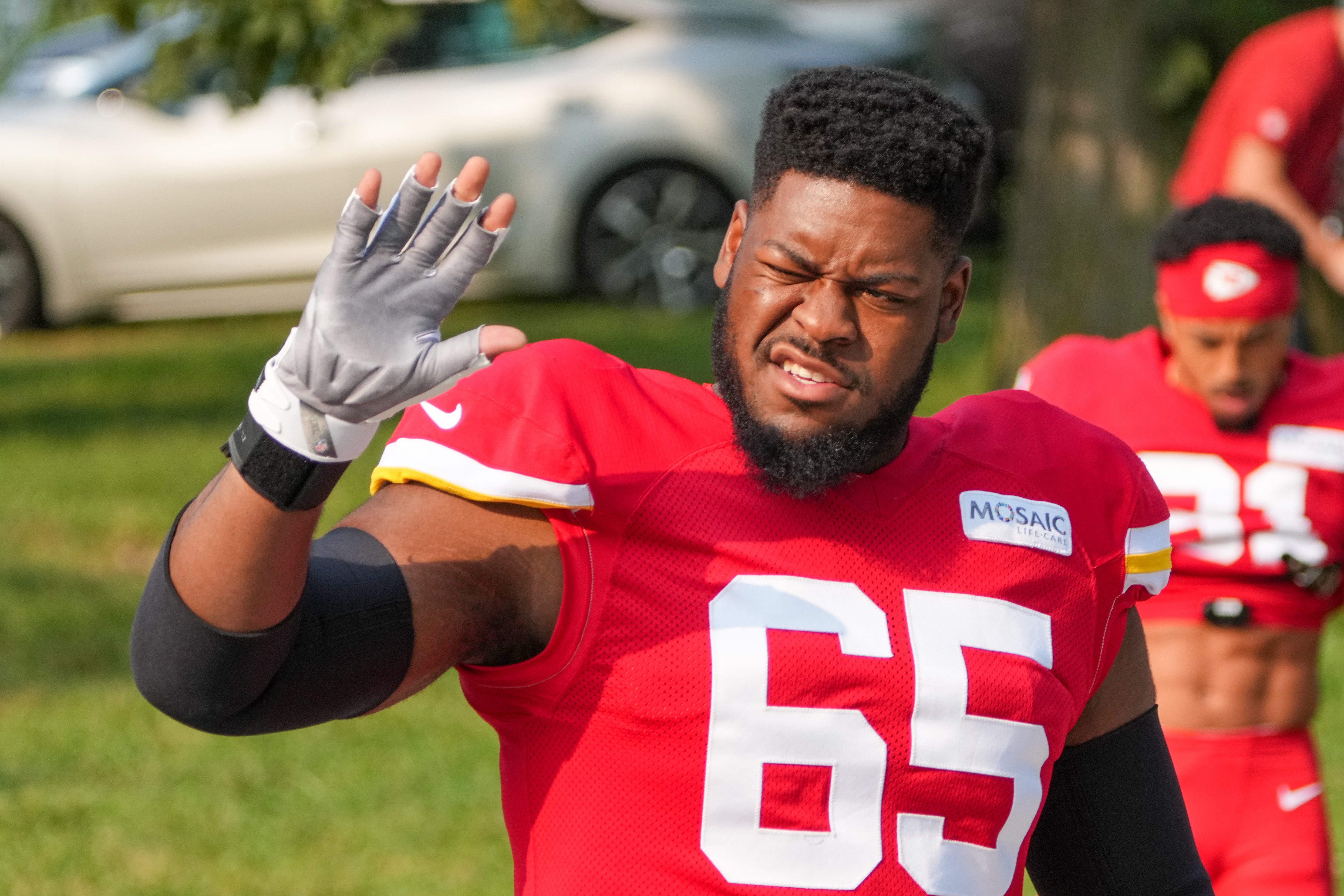 Jul 26, 2024; Kansas City, MO, USA; Kansas City Chiefs guard Trey Smith (65) waves to fans while walking from the locker room to the fields prior to training camp at Missouri Western State University.