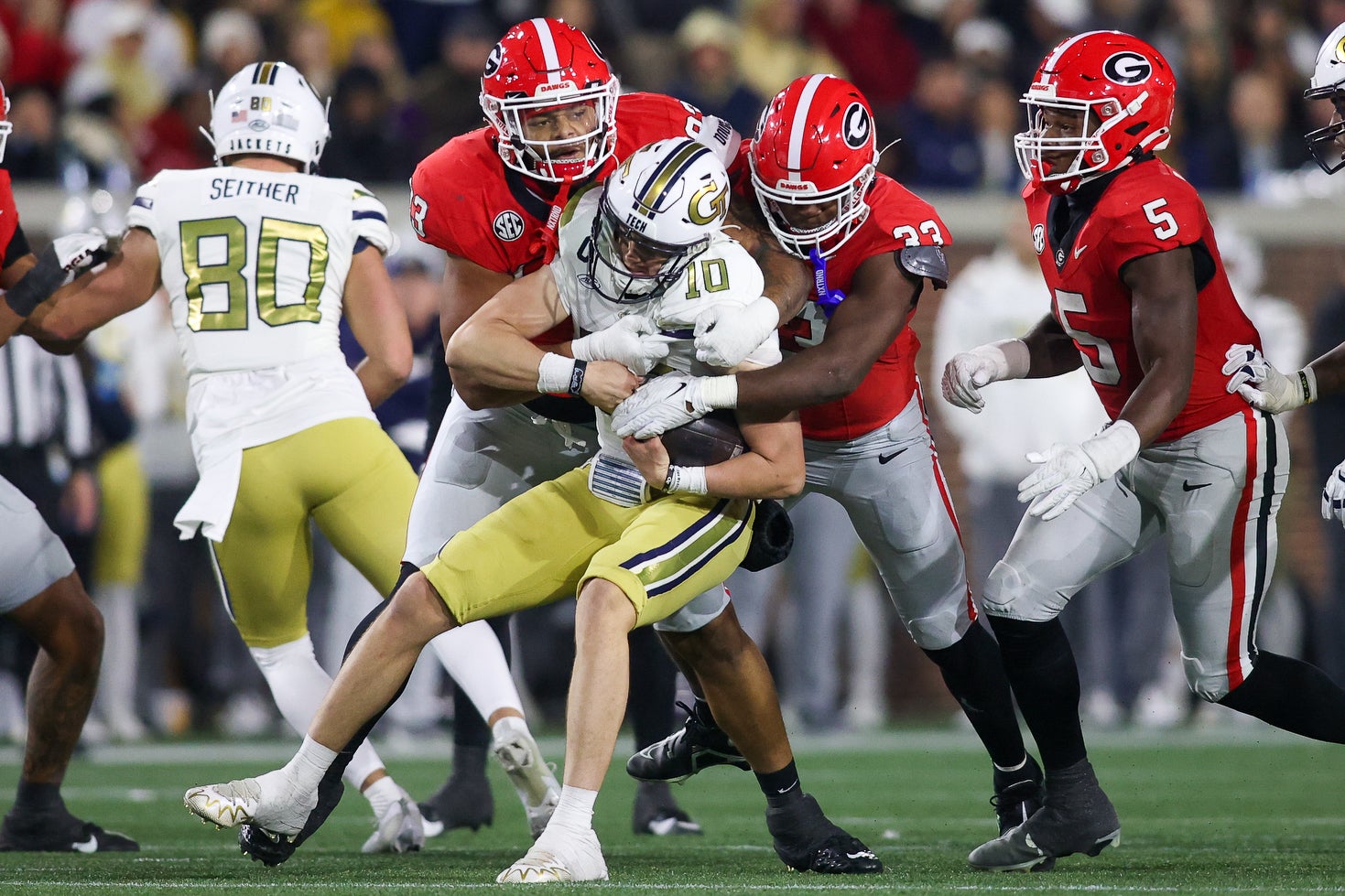 Georgia Bulldogs defensive lineman Tyrion Ingram-Dawkins (93) and linebacker C.J. Allen (33) tackle Georgia Tech Yellow Jackets quarterback Haynes King (10) in the second half at Bobby Dodd Stadium.
