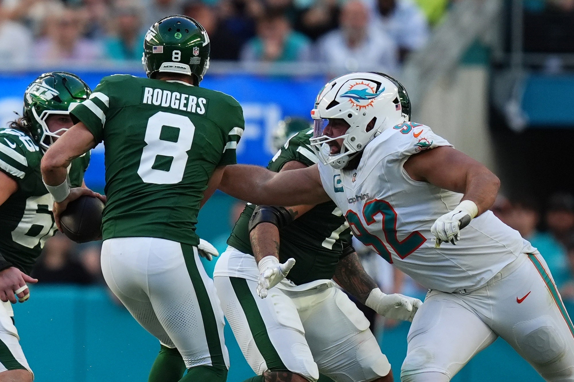 Miami Dolphins defensive tackle Zach Sieler (92) reaches for New York Jets quarterback Aaron Rodgers (8) during the second half at Hard Rock Stadium.