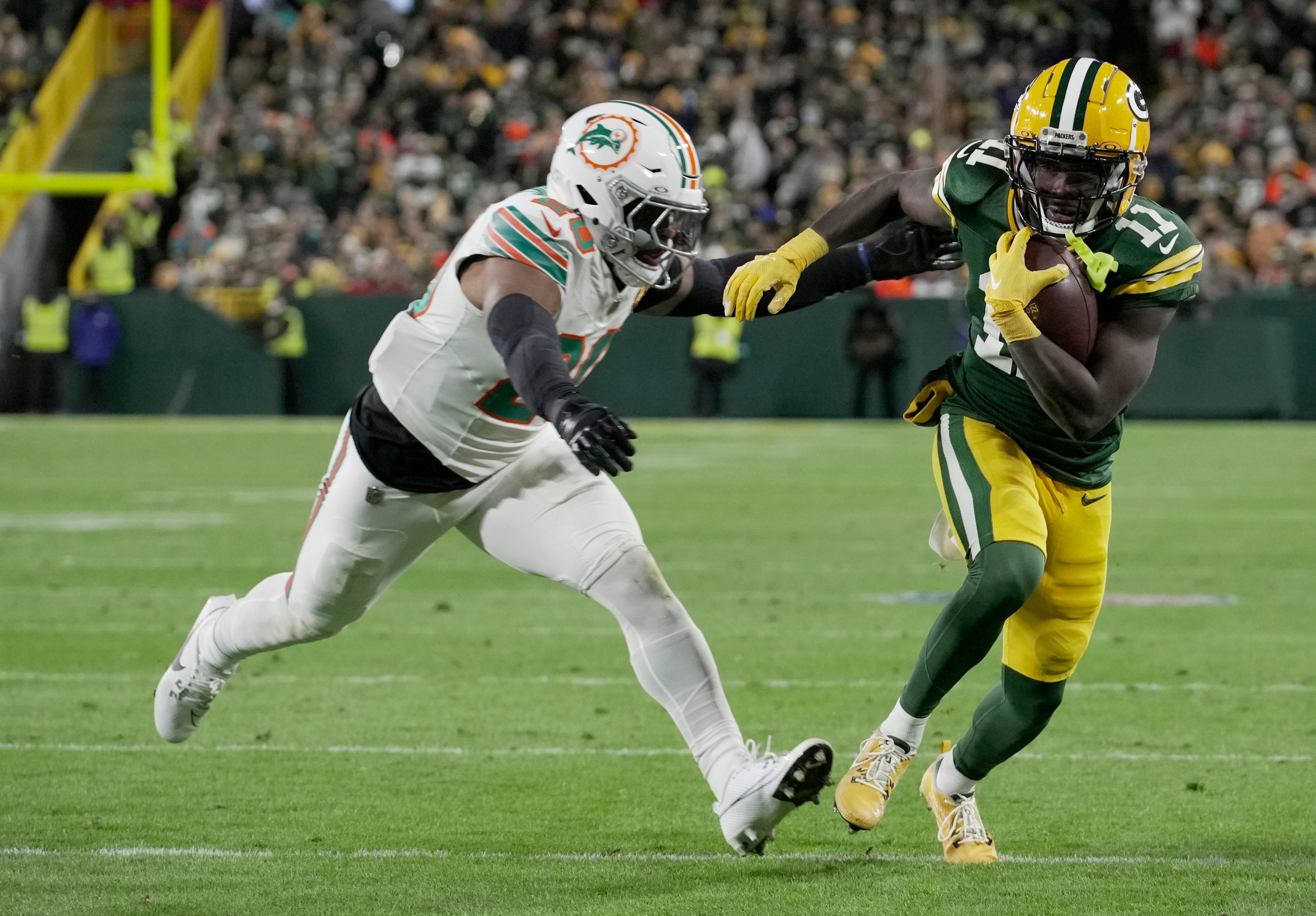 Green Bay Packers wide receiver Jayden Reed (11) outruns Miami Dolphins linebacker Jordyn Brooks (20) to score a touchdown on a reception during the second quarter of their game Thursday, November 28, 2024 at Lambeau Field in Green Bay, Wisconsin.