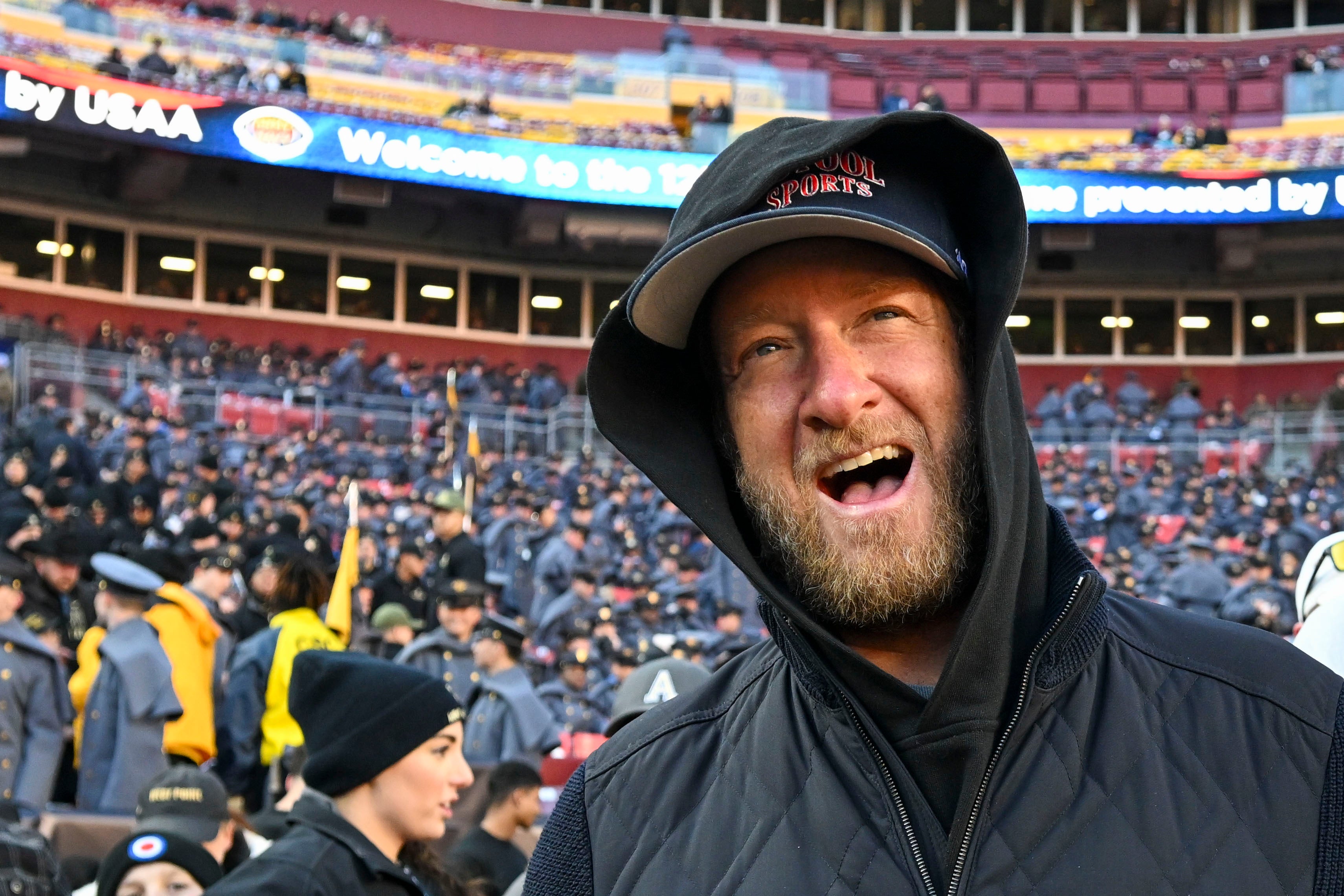 Dec 14, 2024; Landover, Maryland, USA; Dave Portnoy, Bar Stool Sports founder and owner walks along the sidelines before the playing of the 125 Army Navy game at Commanders Field. Mandatory Credit: Tommy Gilligan-Imagn Images Dec 14, 2024; Landover, Maryland, USA; Dave Portnoy poses with solders before the between the Army Black Knights and the Navy Midshipmen at Commanders Field.
