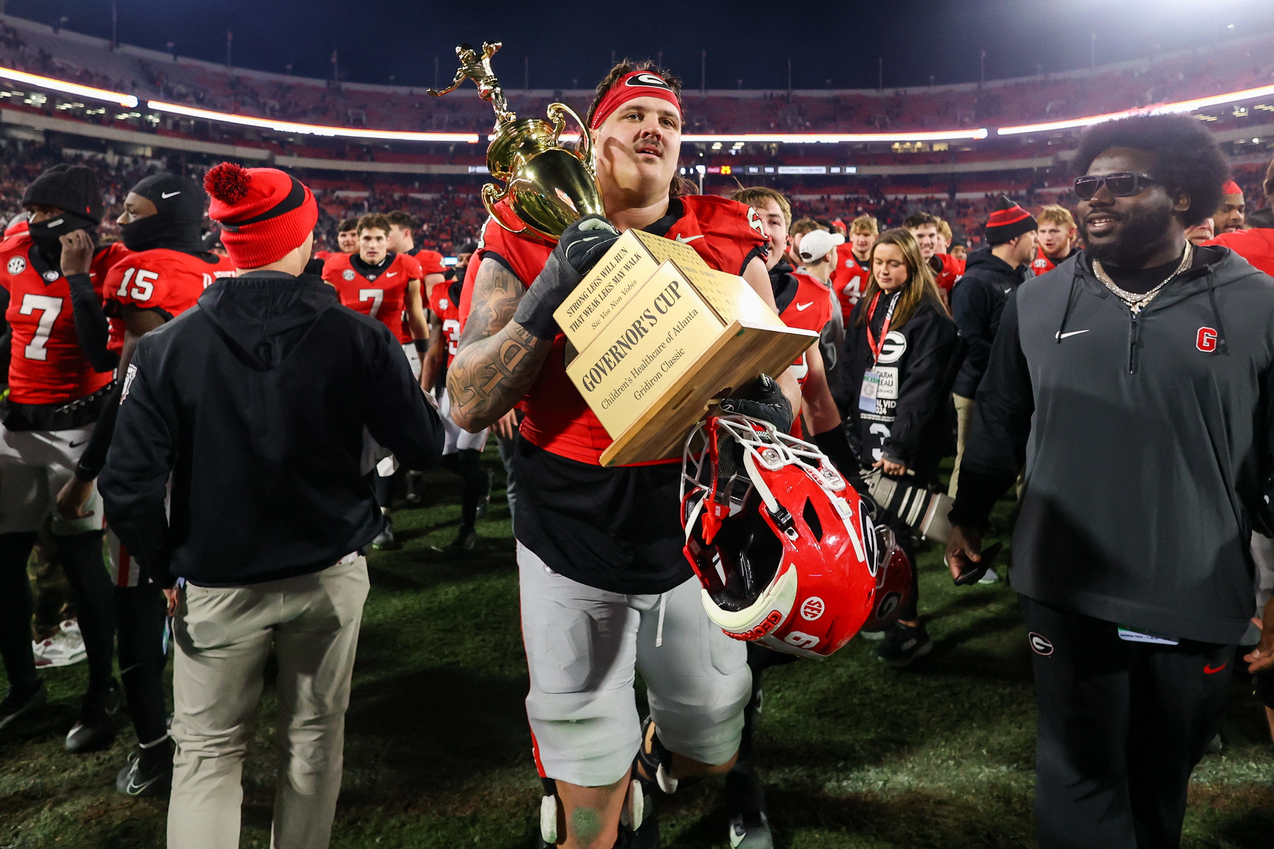 Georgia Bulldogs offensive lineman Tate Ratledge (69) holds the Governors Cup with running back Cash Jones (32) after a victory over the Georgia Tech Yellow Jackets in eight overtimes at Sanford Stadium.