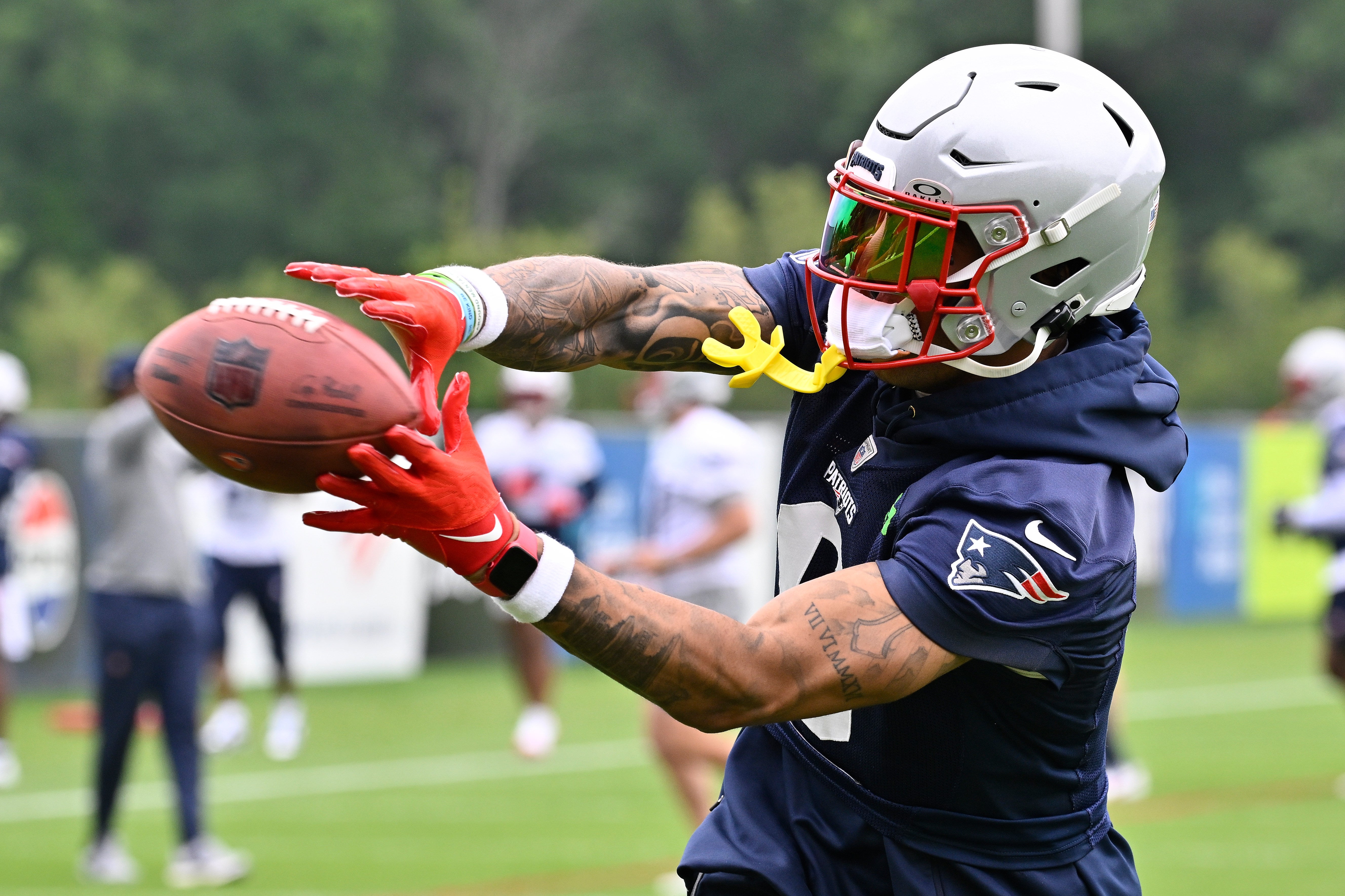 New England Patriots cornerback Christian Gonzalez (0) makes a catch during minicamp at Gillette Stadium.