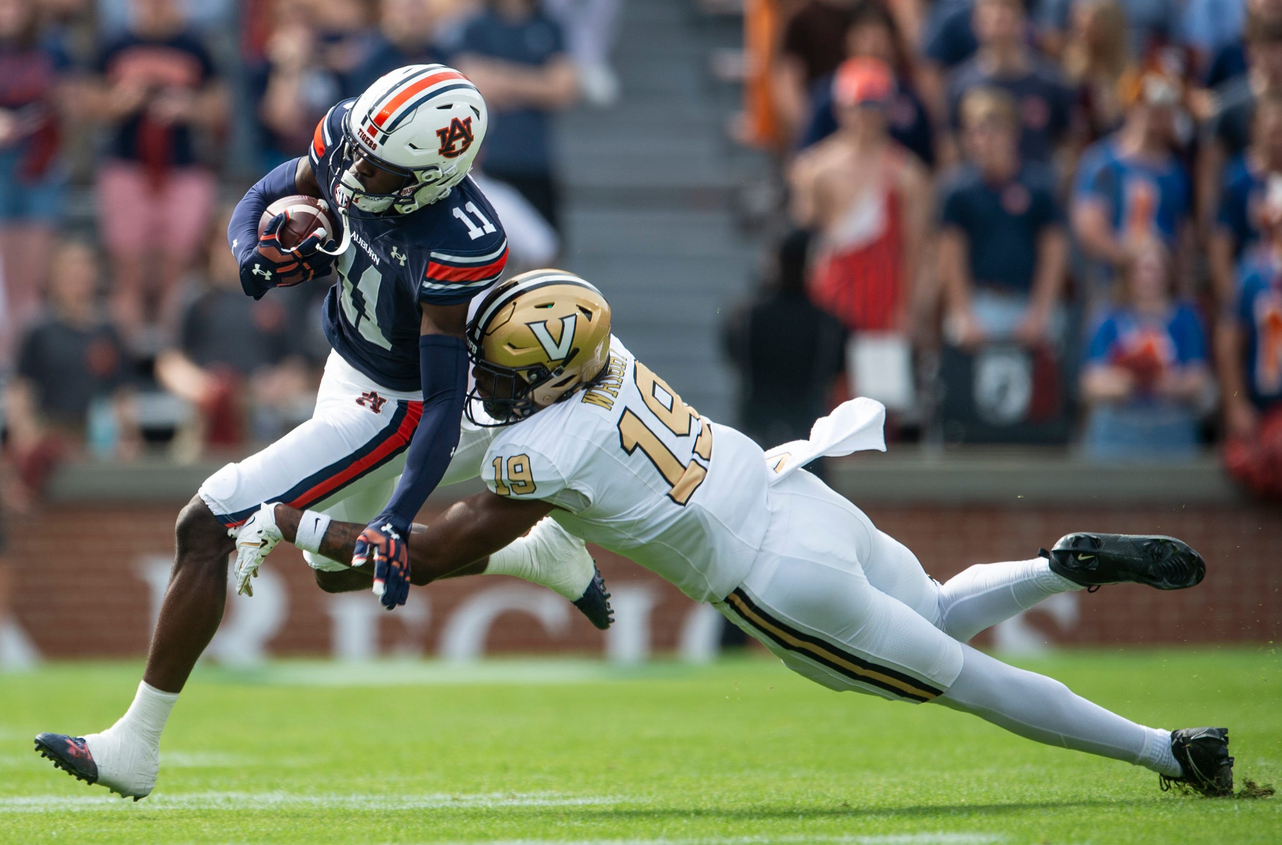 Auburn Tigers wide receiver Malcolm Simmons (11) turns upfield after a catch tackled by Vanderbilt Commodores safety De'Rickey Wright (19) as Auburn Tigers take on Vanderbilt Commodores at Jordan-Hare Stadium in Auburn, Ala., on Saturday, Nov. 2, 2024.