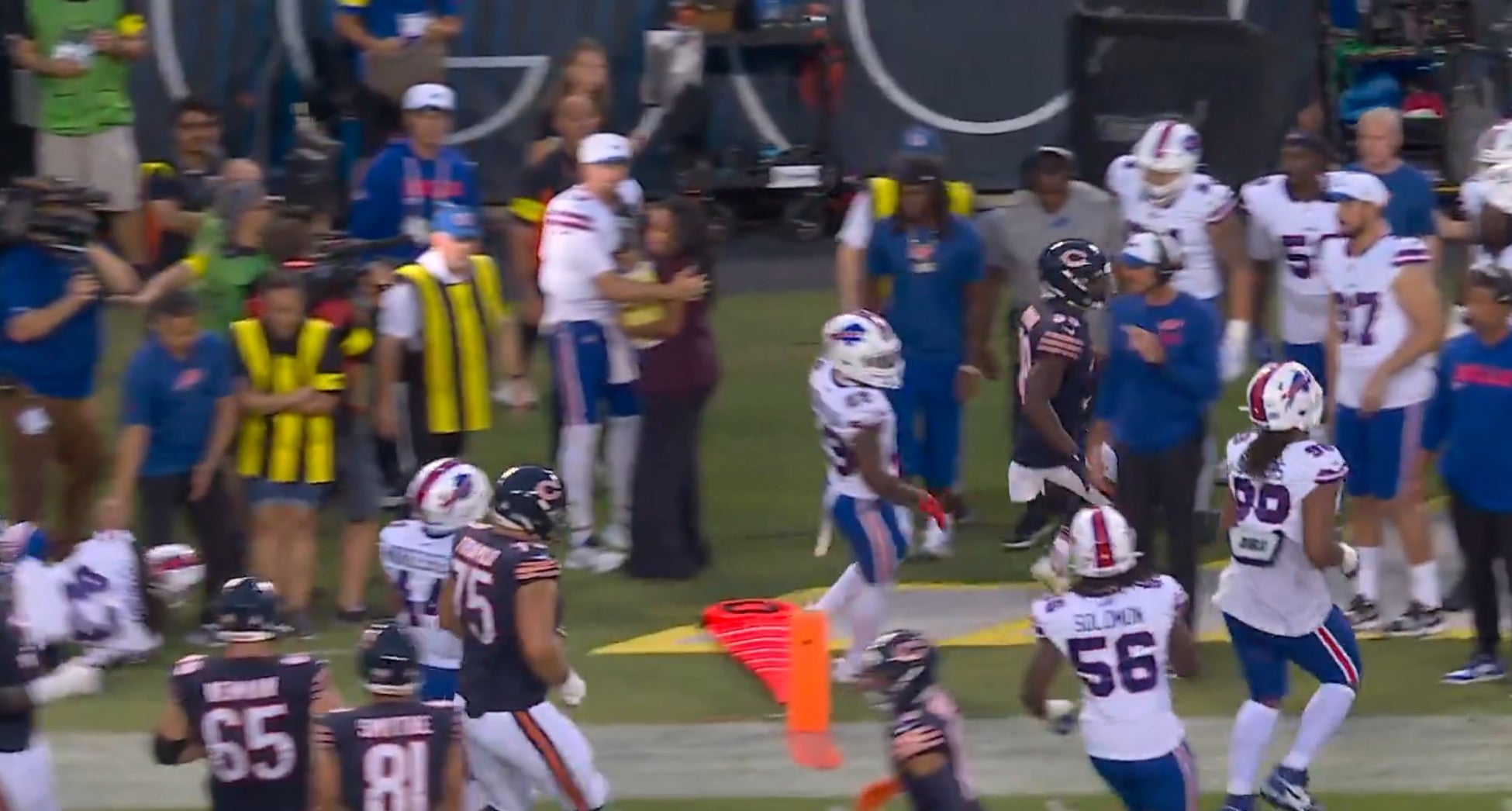 Buffalo Bills QB Josh Allen helps Pam Oliver on sideline as players crash into their interview