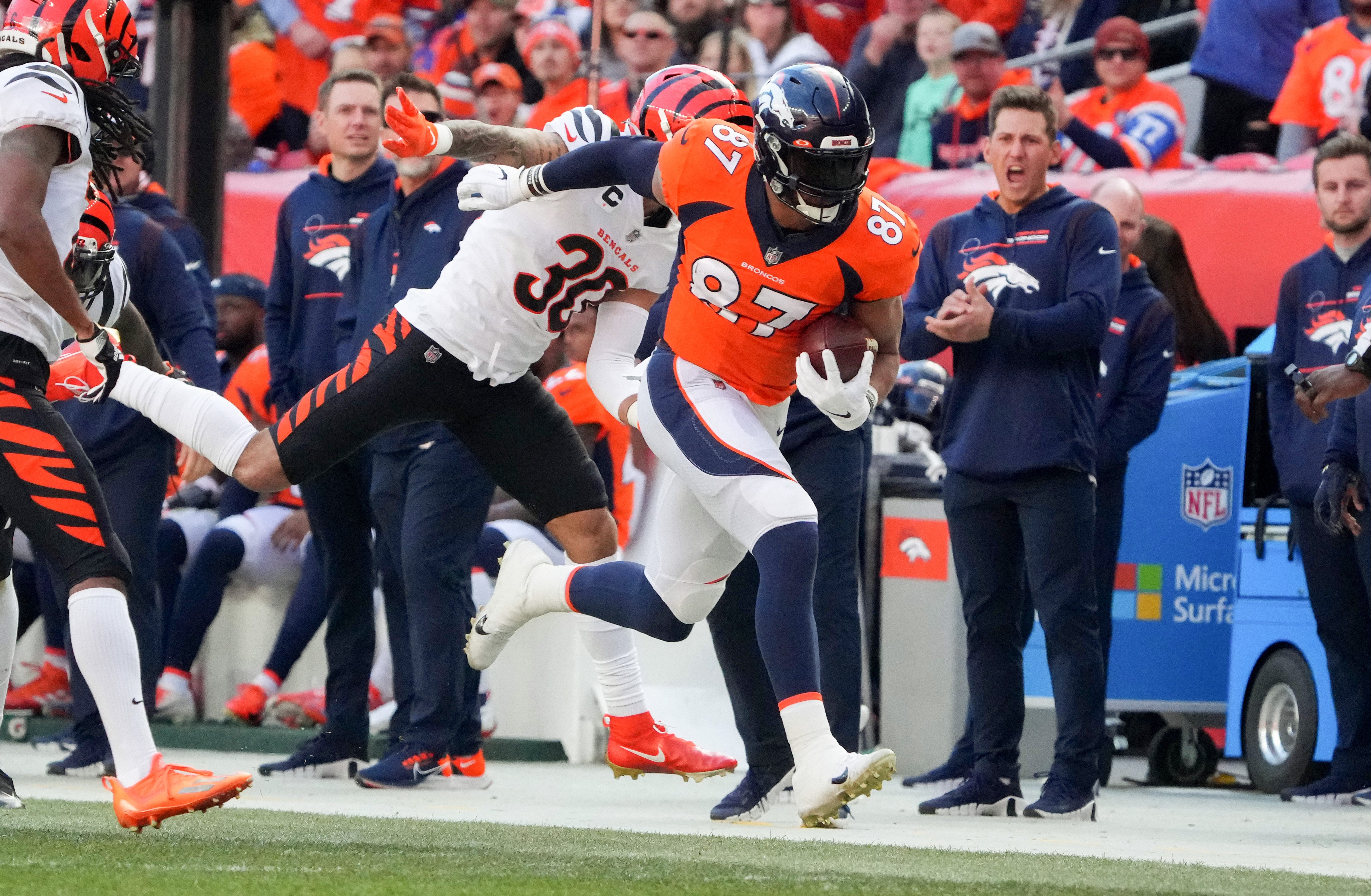 Dec 19, 2021; Denver, Colorado, USA; Denver Broncos tight end Noah Fant (87) carries the ball past Cincinnati Bengals free safety Jessie Bates (30) in the first quarter at Empower Field at Mile High.