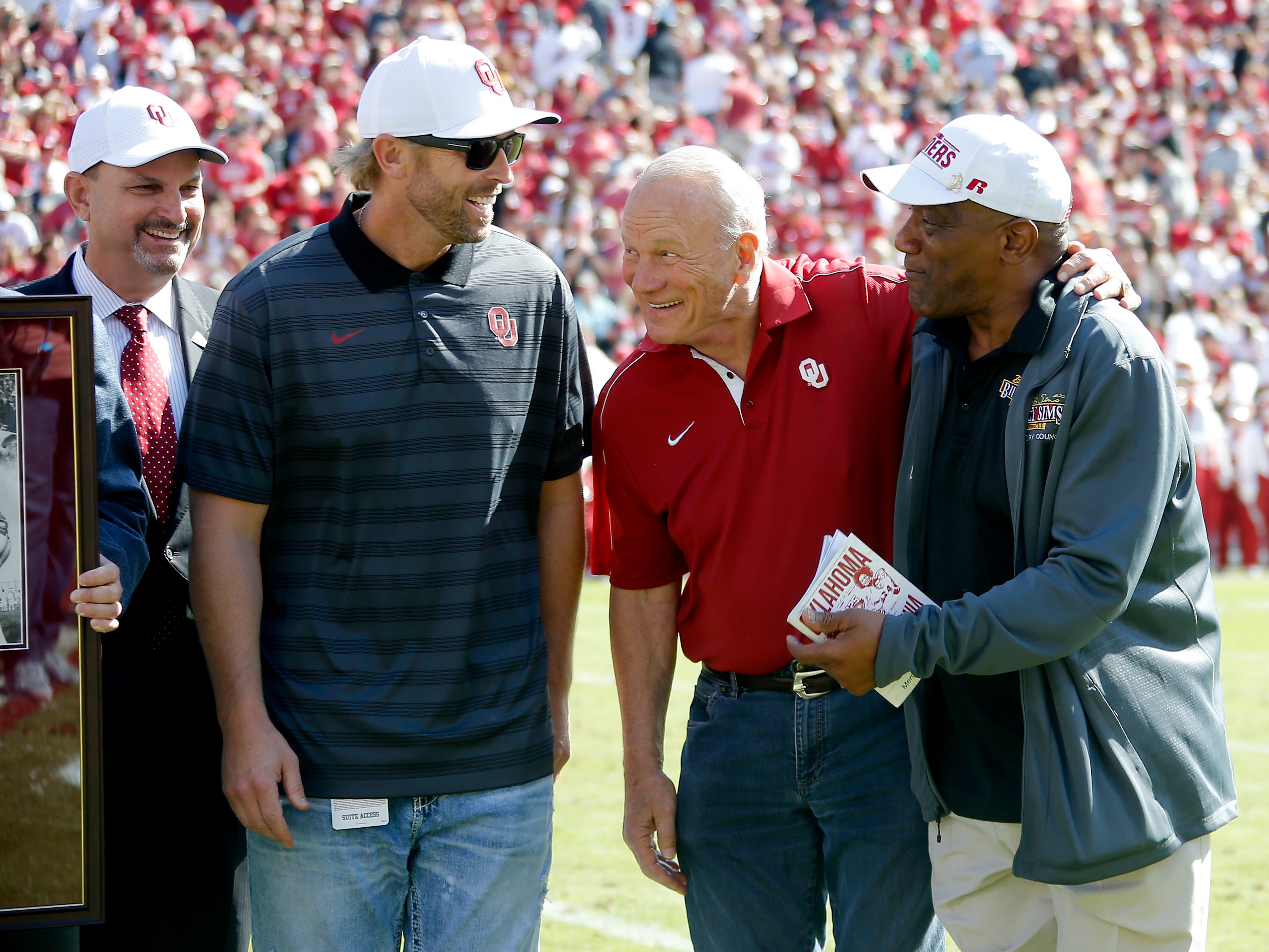 From left, Oklahoma athletic director Joe Castiglione, fomer Heisman Trophy winners Jason White, second from left, and Billy Sims, at right, with former Oklahoma coach Barry Switzer gather during halftime of a college football game between the University of Oklahoma Sooners (OU) and the West Virginia Mountaineers at Gaylord Family-Oklahoma Memorial Stadium in Norman, Okla, Saturday, Oct. 19, 2019. Oklahoma won 52-14. 88aafd16bfa844a7fe3cc632d5ba1e1d