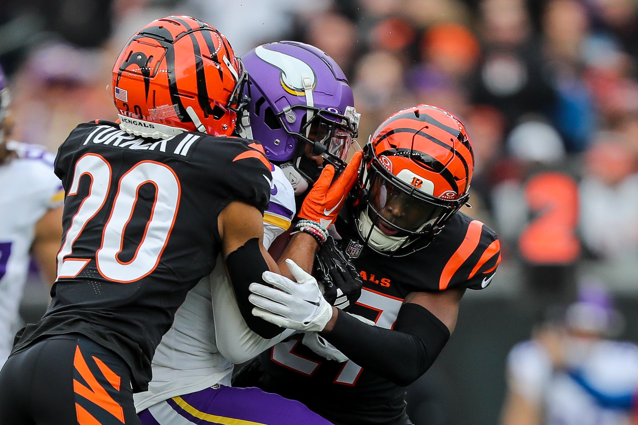 Dec 16, 2023; Cincinnati, Ohio, USA; Cincinnati Bengals cornerback DJ Turner II (20) and safety Jordan Battle (27) tackle Minnesota Vikings wide receiver Jordan Addison (3) in the first half at Paycor Stadium.