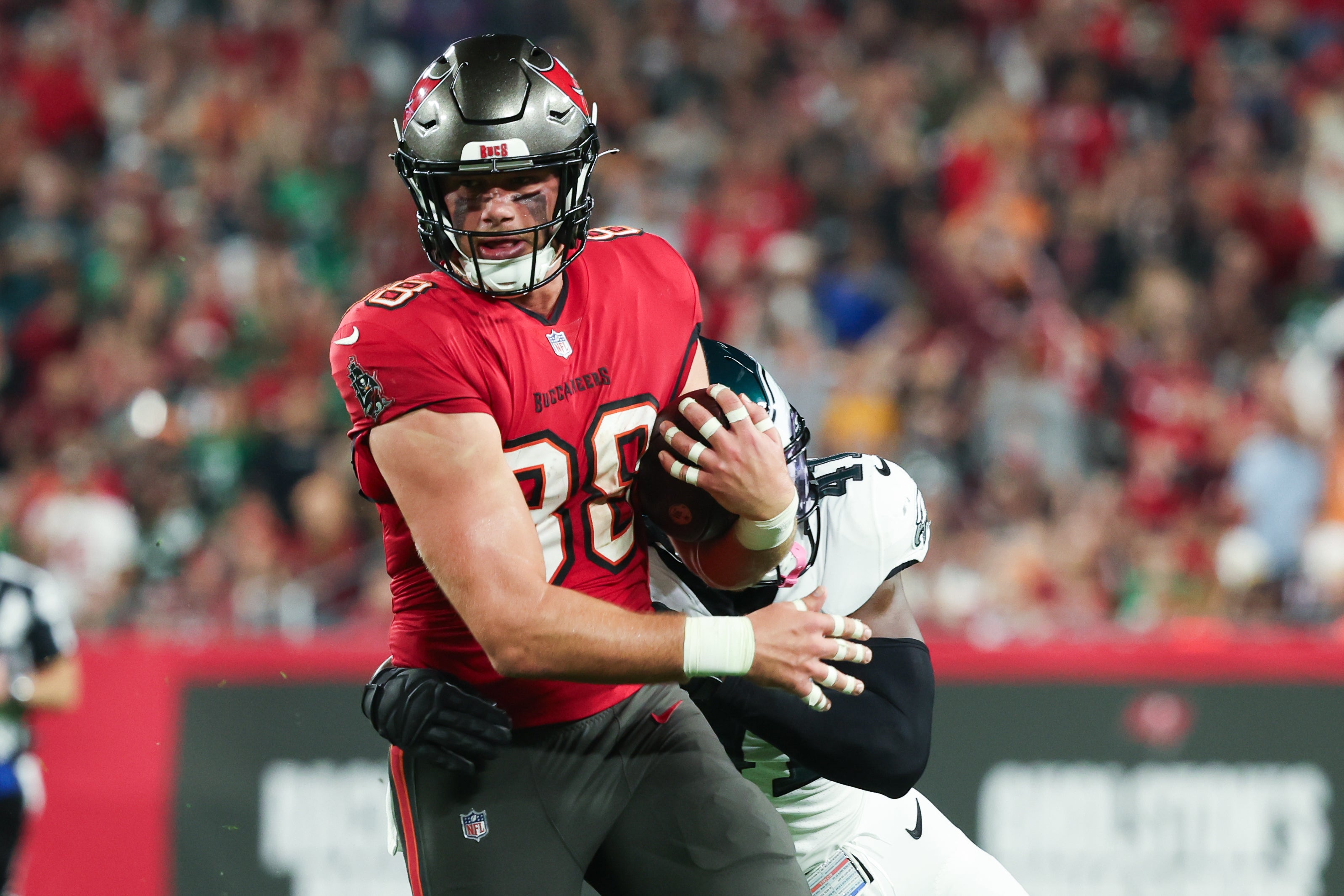 Jan 15, 2024; Tampa, Florida, USA; Tampa Bay Buccaneers tight end Cade Otton (88) breaks a tackle by Philadelphia Eagles linebacker Nicholas Morrow (41) during the first half of a 2024 NFC wild card game at Raymond James Stadium.