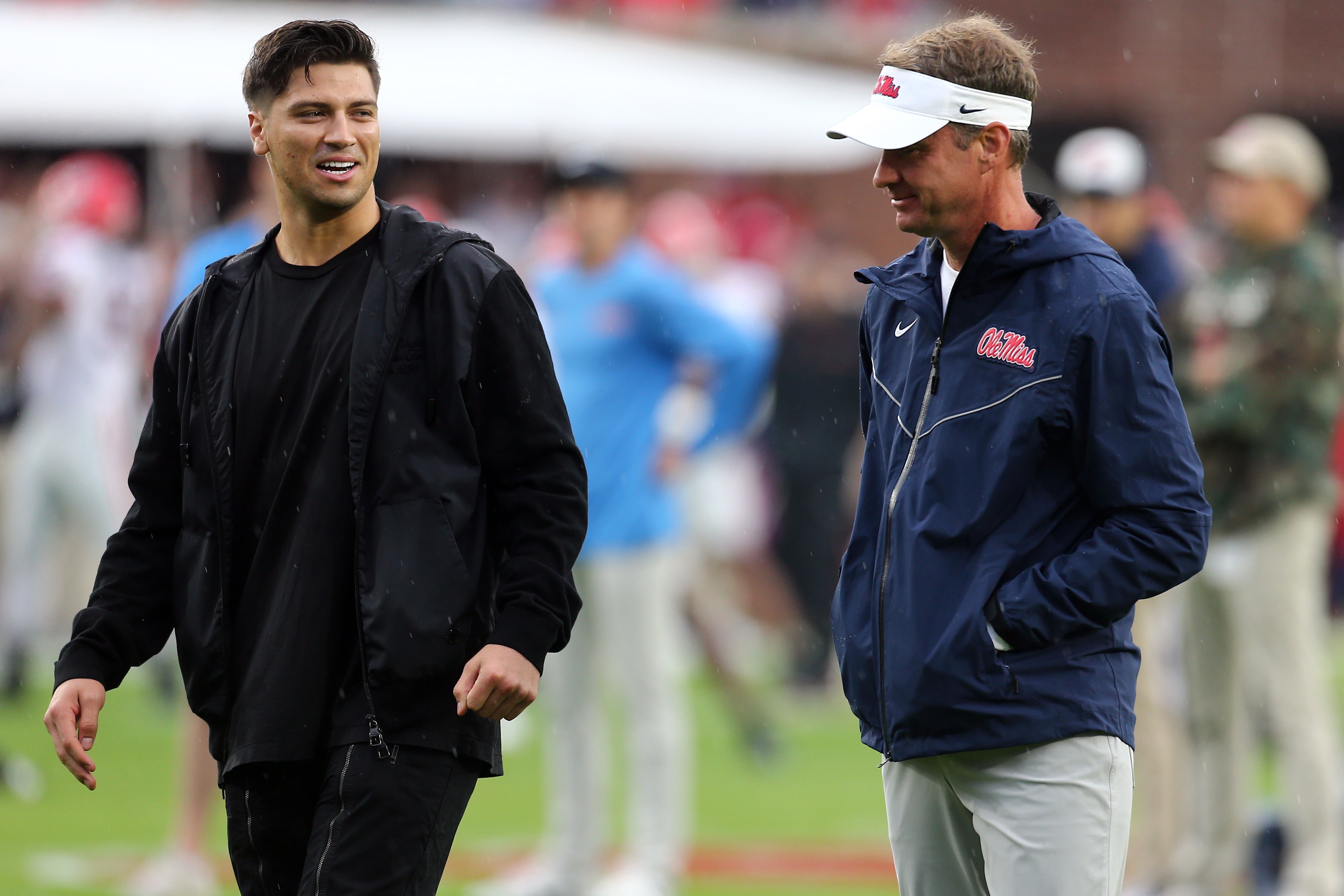 Nov 9, 2024; Oxford, Mississippi, USA; Mississippi Rebels head coach Lane Kiffin (right) talks with former Mississippi Rebels quarterback Matt Corral prior to the game against the Georgia Bulldogs at Vaught-Hemingway Stadium.