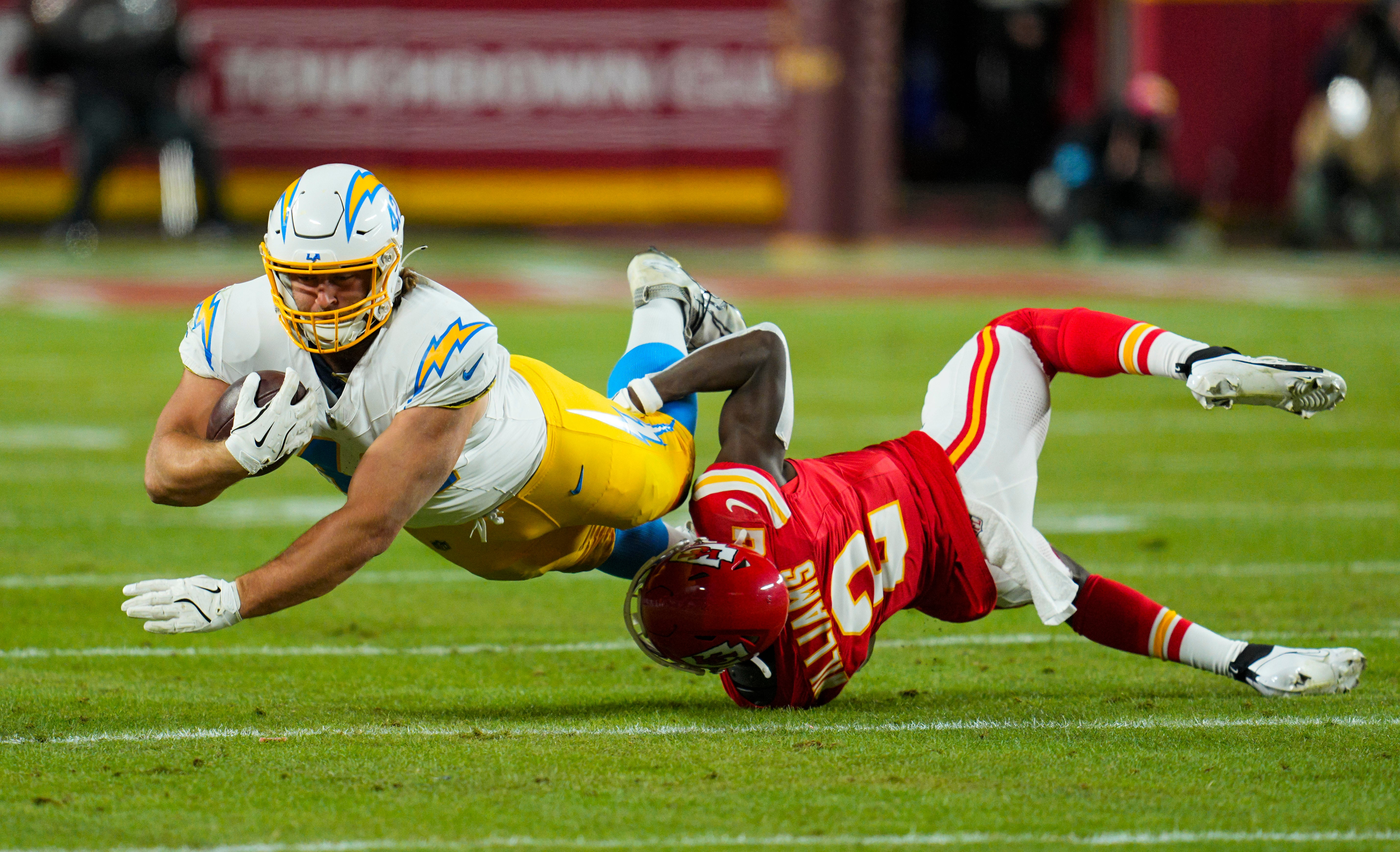 Los Angeles Chargers tight end Tucker Fisk (42) is tackled by Kansas City Chiefs cornerback Joshua Williams (2) during the first half at GEHA Field at Arrowhead Stadium.