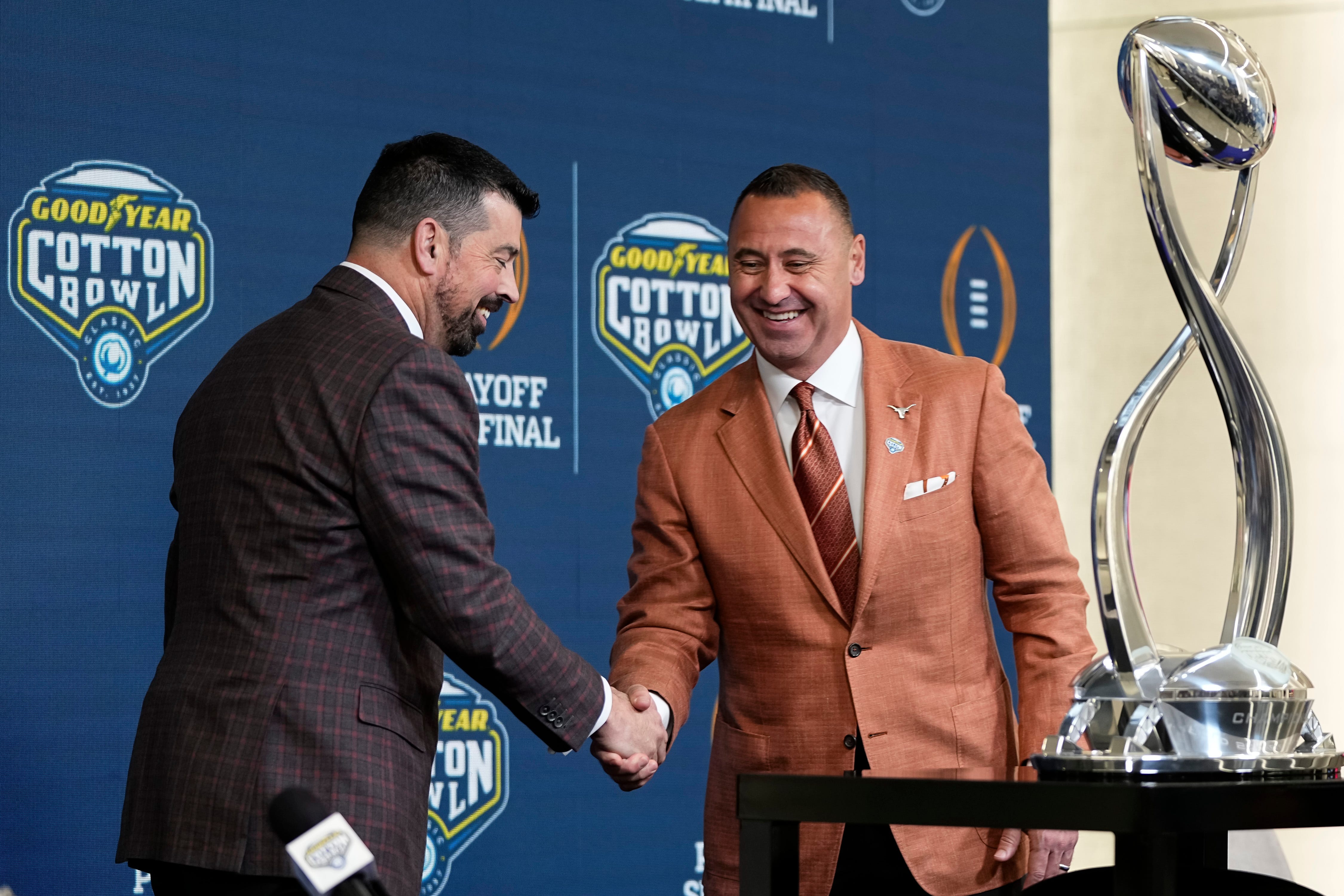 Ohio State Buckeyes head coach Ryan Day and Texas Longhorns head coach Steve Sarkisian shake hands following a press conference at AT&T Stadium prior to the College Football Playoff semifinal at the Cotton Bowl Classic in Arlington, Texas on Jan. 9, 2025.