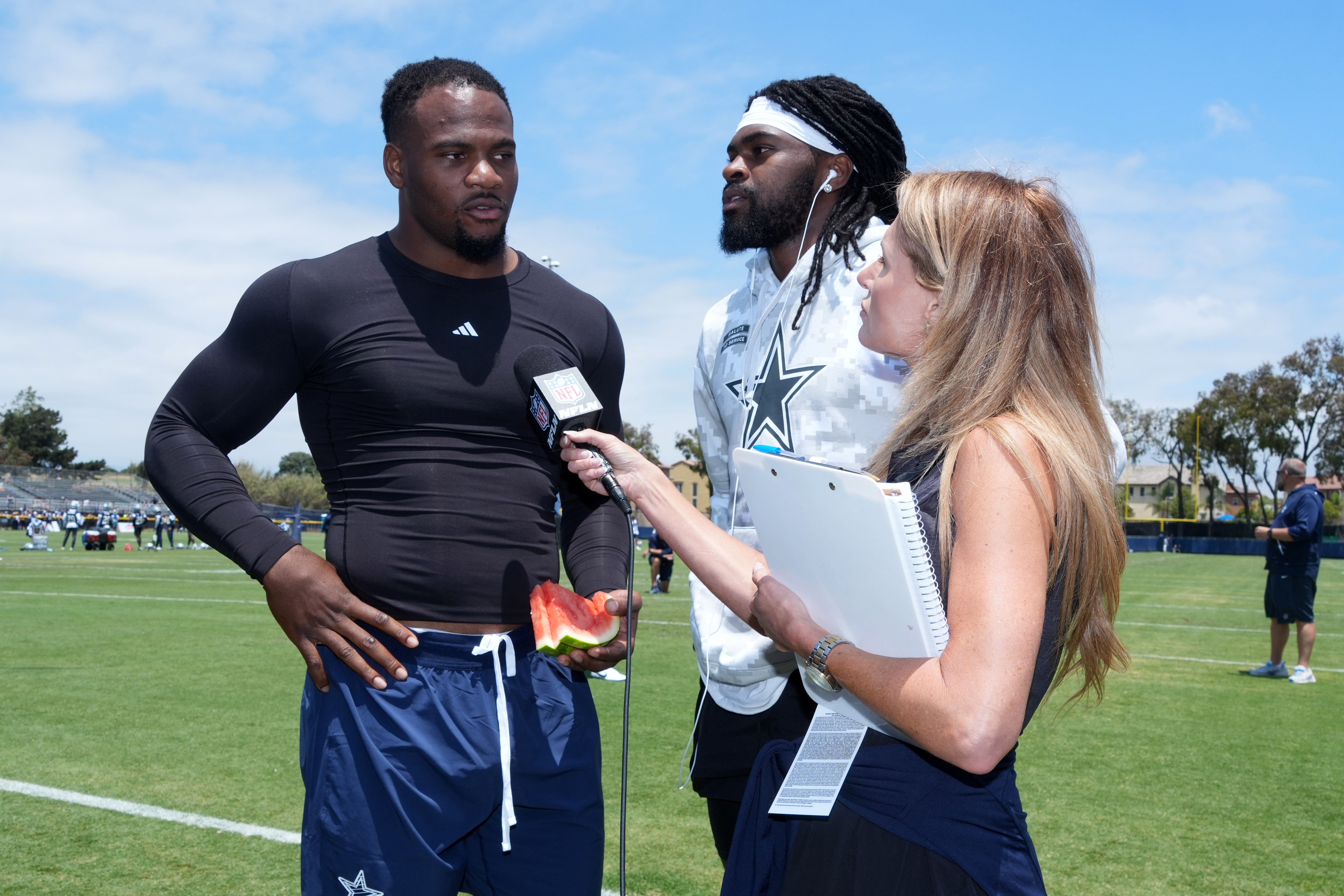 Jul 22, 2025; Oxnard, CA, USA; NFL Network reporter Jane Slater (right) interviews Dallas Cowboys defensive end Micah Parsons (left) and cornerback Trevon Diggs (center) during training camp at the River Ridge Fields.