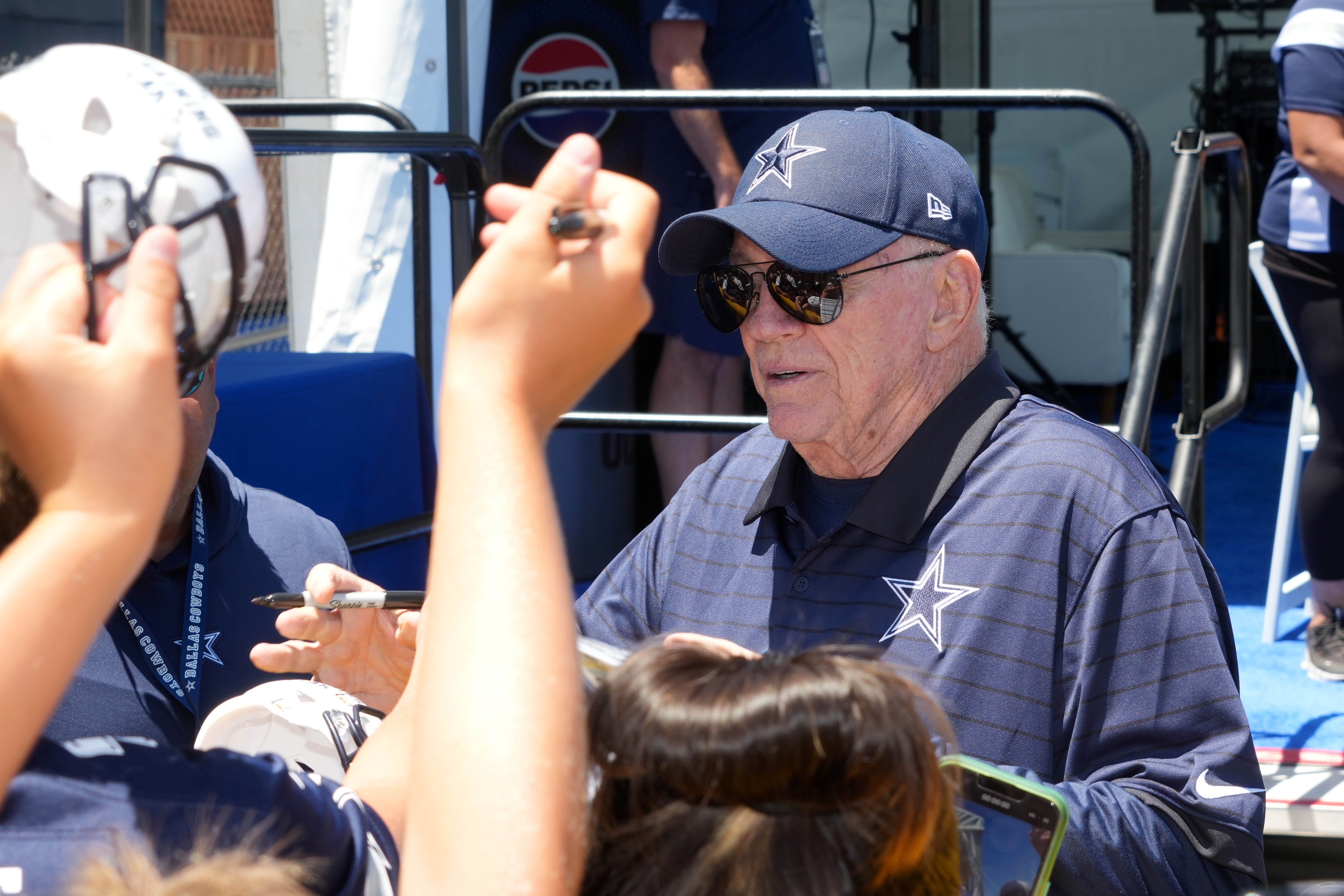 Dallas Cowboys owner Jerry Jones signs autographs at training camp at the River Ridge Fields.