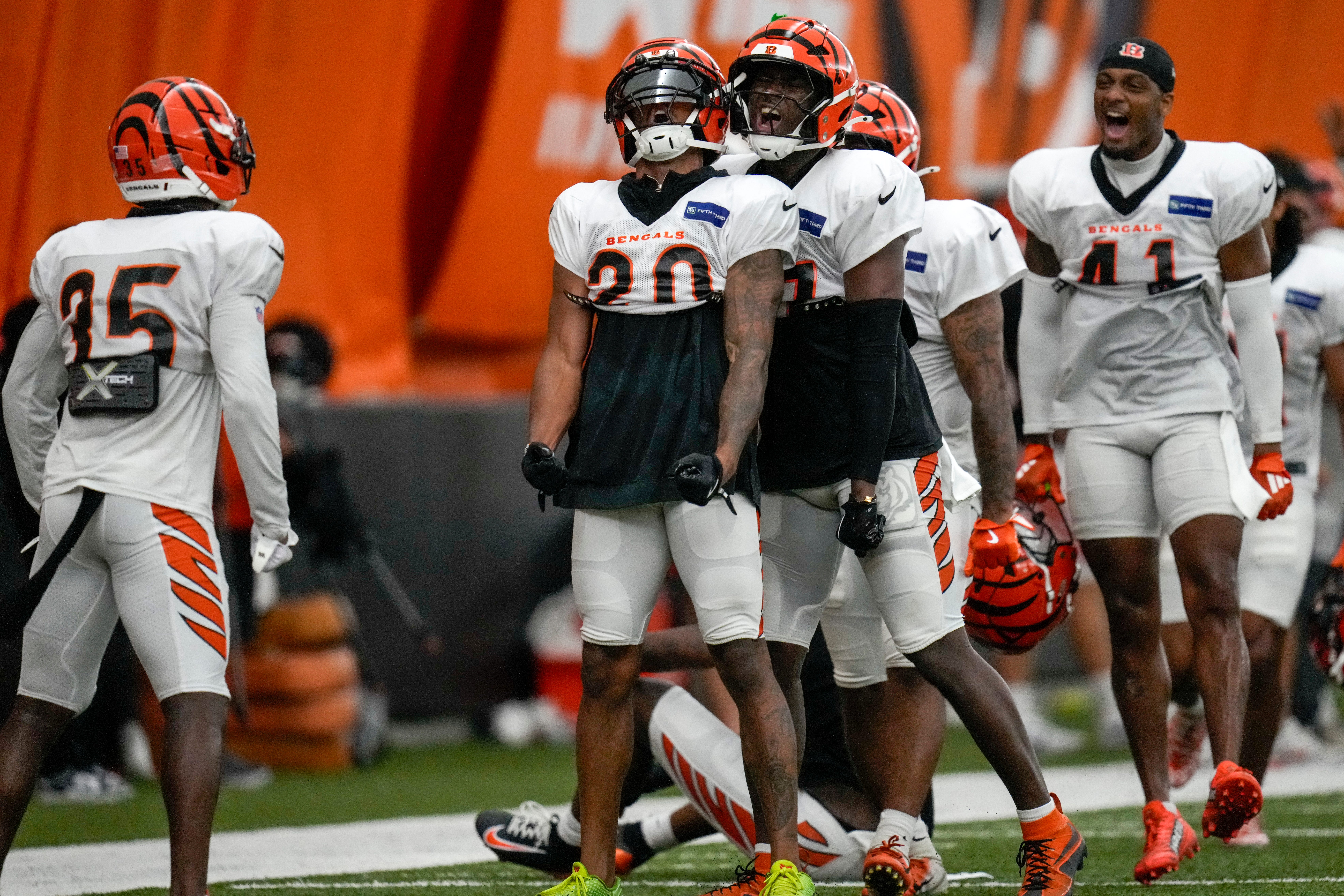 The defense celebrates after Cincinnati Bengals cornerback DJ Turner II (20) breaks up a pass to wide receiver Tee Higgins (5) during a preseason training camp practice in downtown Cincinnati on Thursday, July 31, 2025.