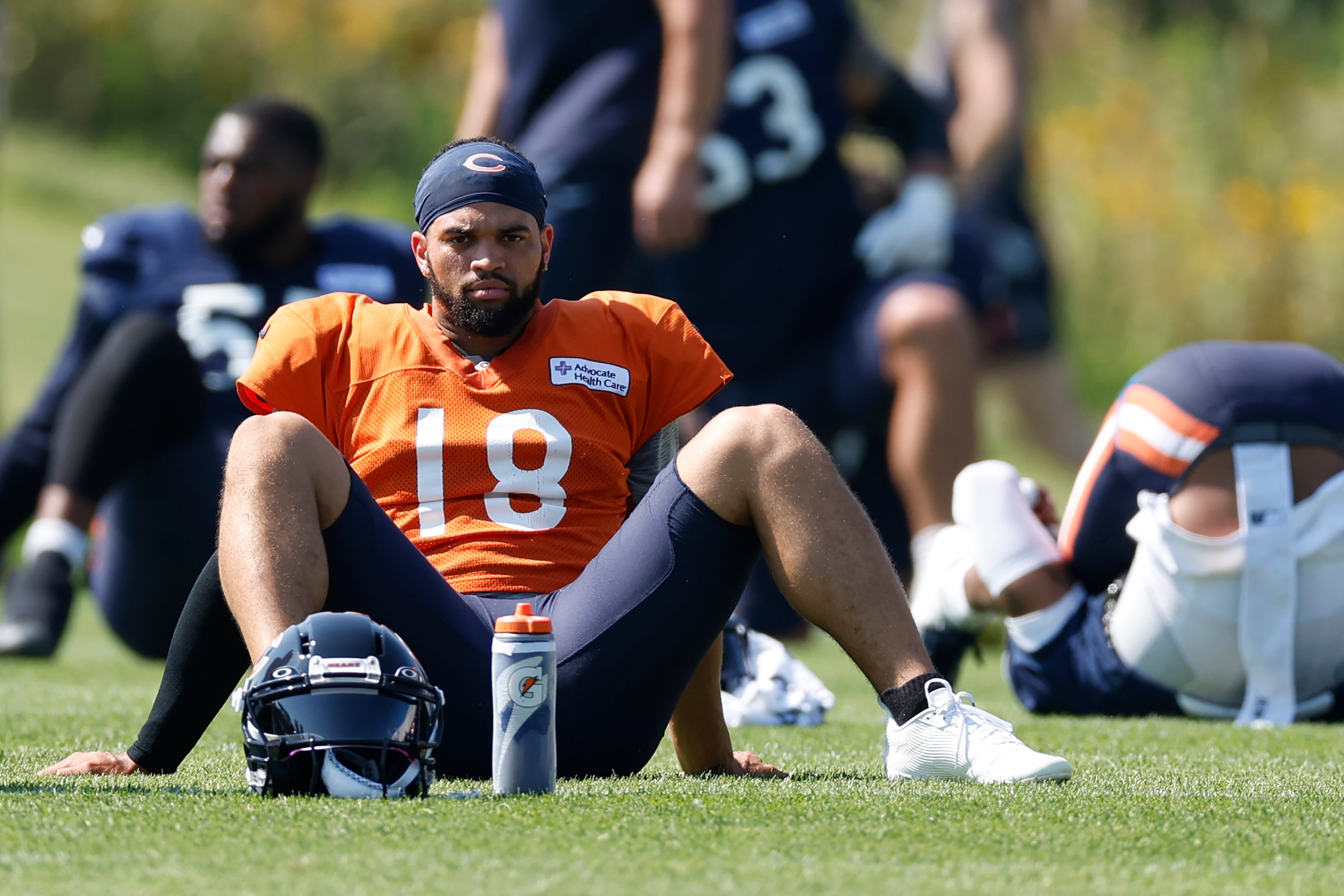Aug 8, 2025; Lake Forest, IL, USA; Chicago Bears quarterback Caleb Williams (18) sits on the field during joint training camp practice with the Miami Dolphins ahead of Sunday's preseason opener.
