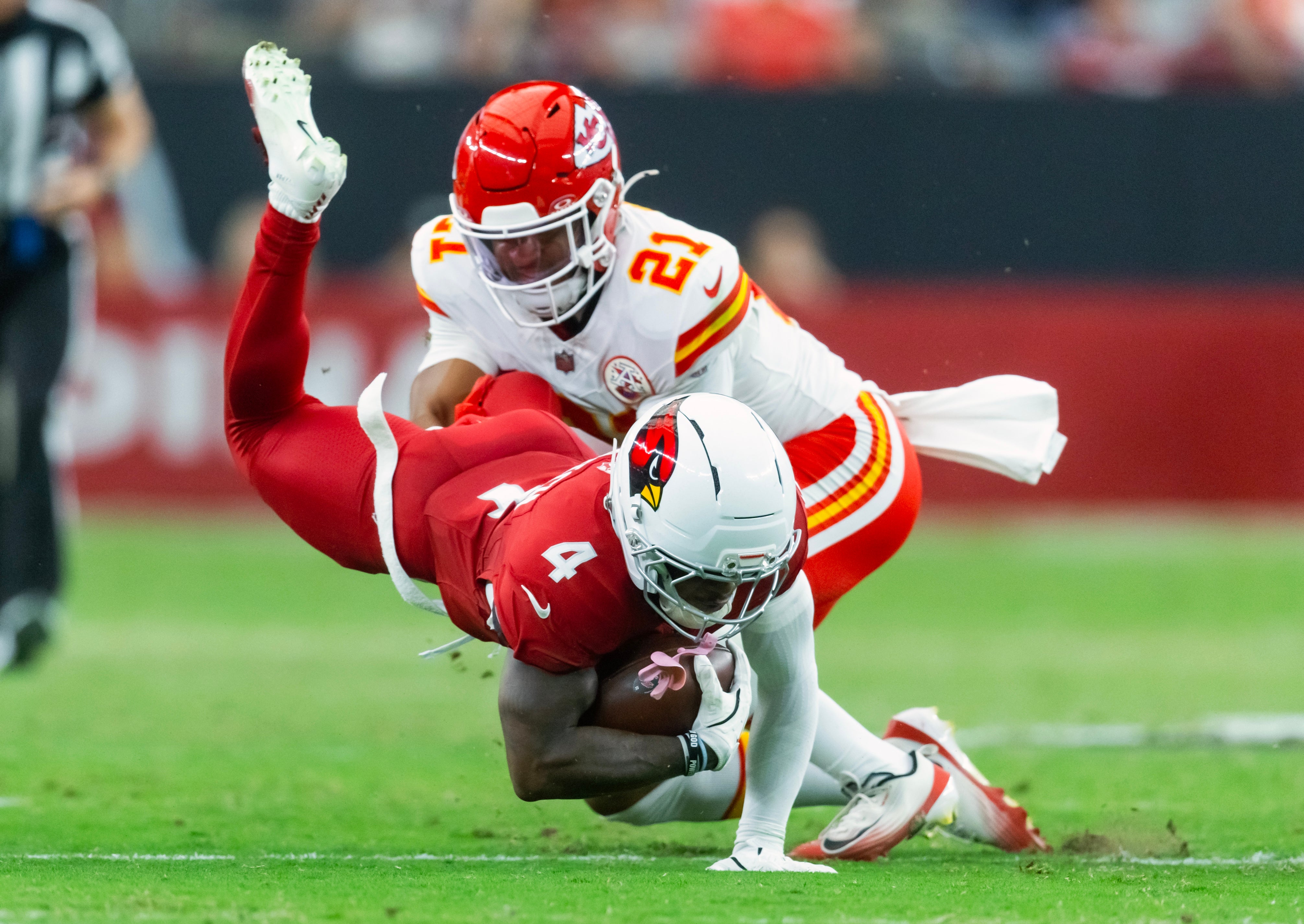 Arizona Cardinals wide receiver Greg Dortch (4) is tackled by Kansas City Chiefs safety Jaden Hicks (21) during a preseason NFL game at State Farm Stadium.