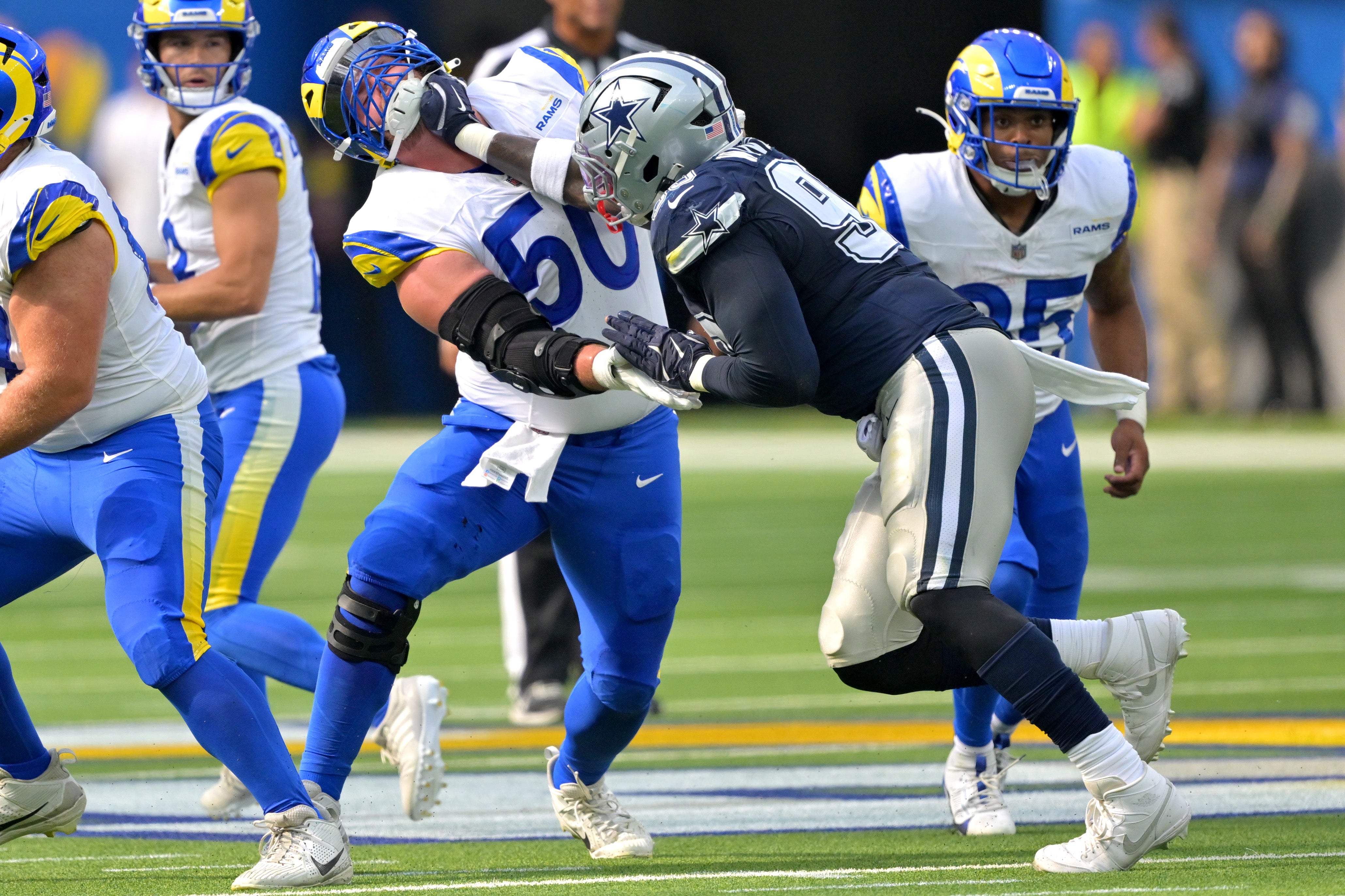 Los Angeles Rams center Beaux Limmer (50) and Dallas Cowboys defensive tackle Perrion Winfrey (99) battle on the line during the first half at SoFi Stadium.