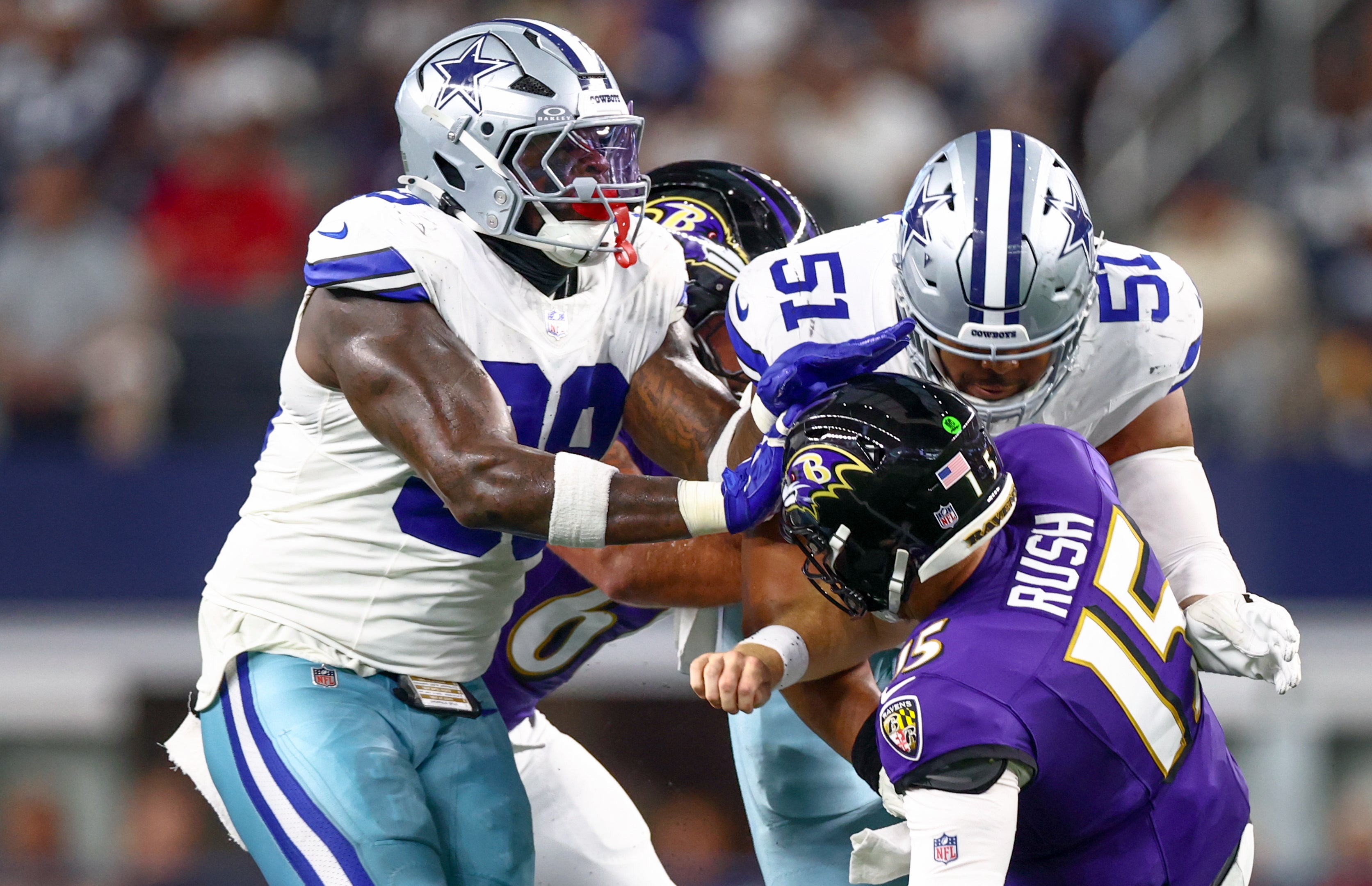 Dallas Cowboys defensive end Earnest Brown IV (51) and Dallas Cowboys defensive tackle Perrion Winfrey (99) pressure Baltimore Ravens quarterback Cooper Rush (15) during the second quarter at AT&T Stadium.