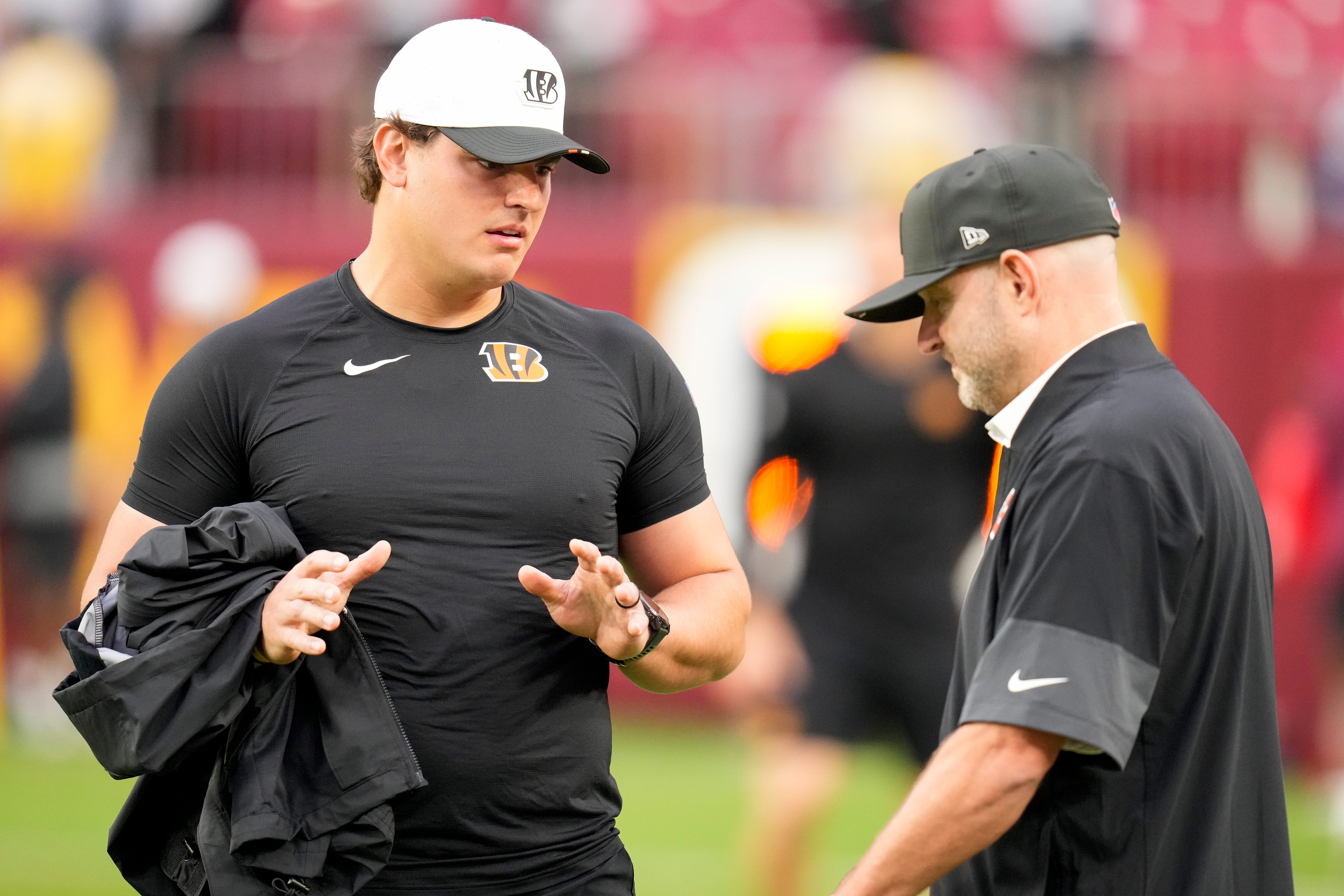 Cincinnati Bengals defensive end Trey Hendrickson (91) talks with director of player personnel Duke Tobin before the first quarter of the NFL Preseason Week 2 game between the Washington Commanders and the Cincinnati Bengals at Northwest Stadium in Landover, Md., on Monday, Aug. 18, 2025.