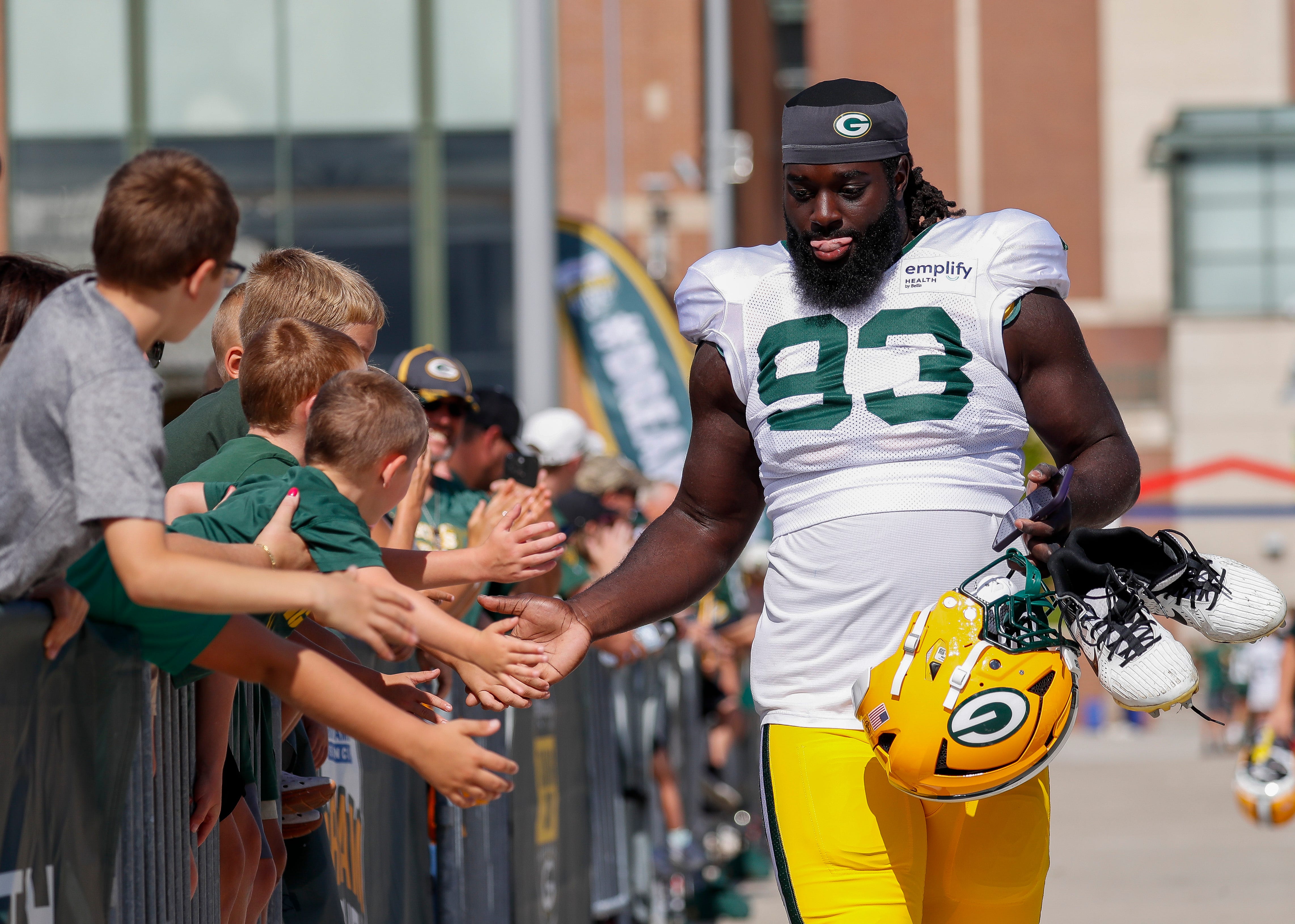 Green Bay Packers defensive lineman Nazir Stackhouse (93) slaps hands with fans as he walks to a joint practice with the Seattle Seahawks on Thursday, August 21, 2025, at Lambeau Field in Green Bay, Wis.