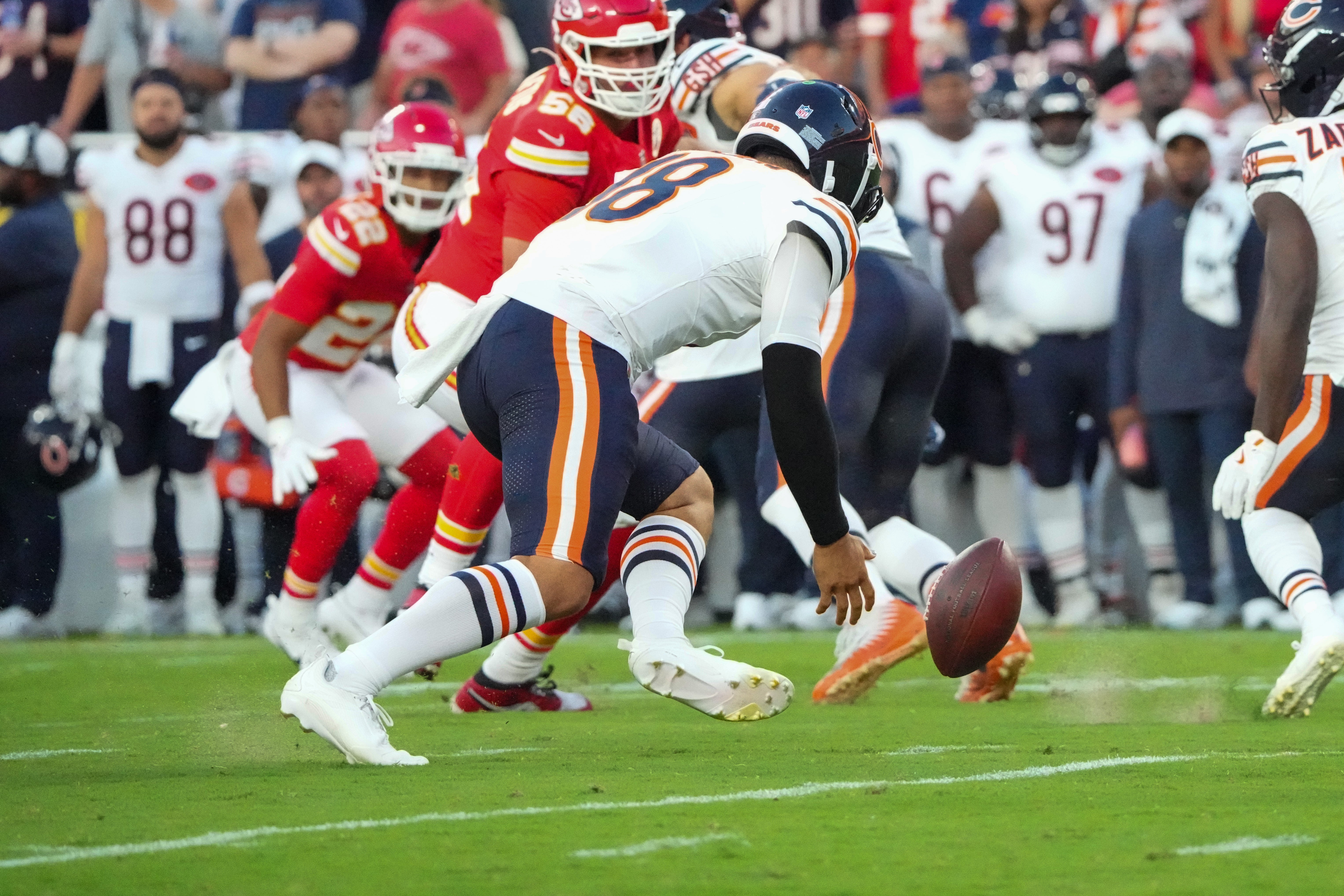 Aug 22, 2025; Kansas City, Missouri, USA; Chicago Bears quarterback Caleb Williams (18) fumbles a handoff against the Chicago Bears during the first half of the game at GEHA Field at Arrowhead Stadium.