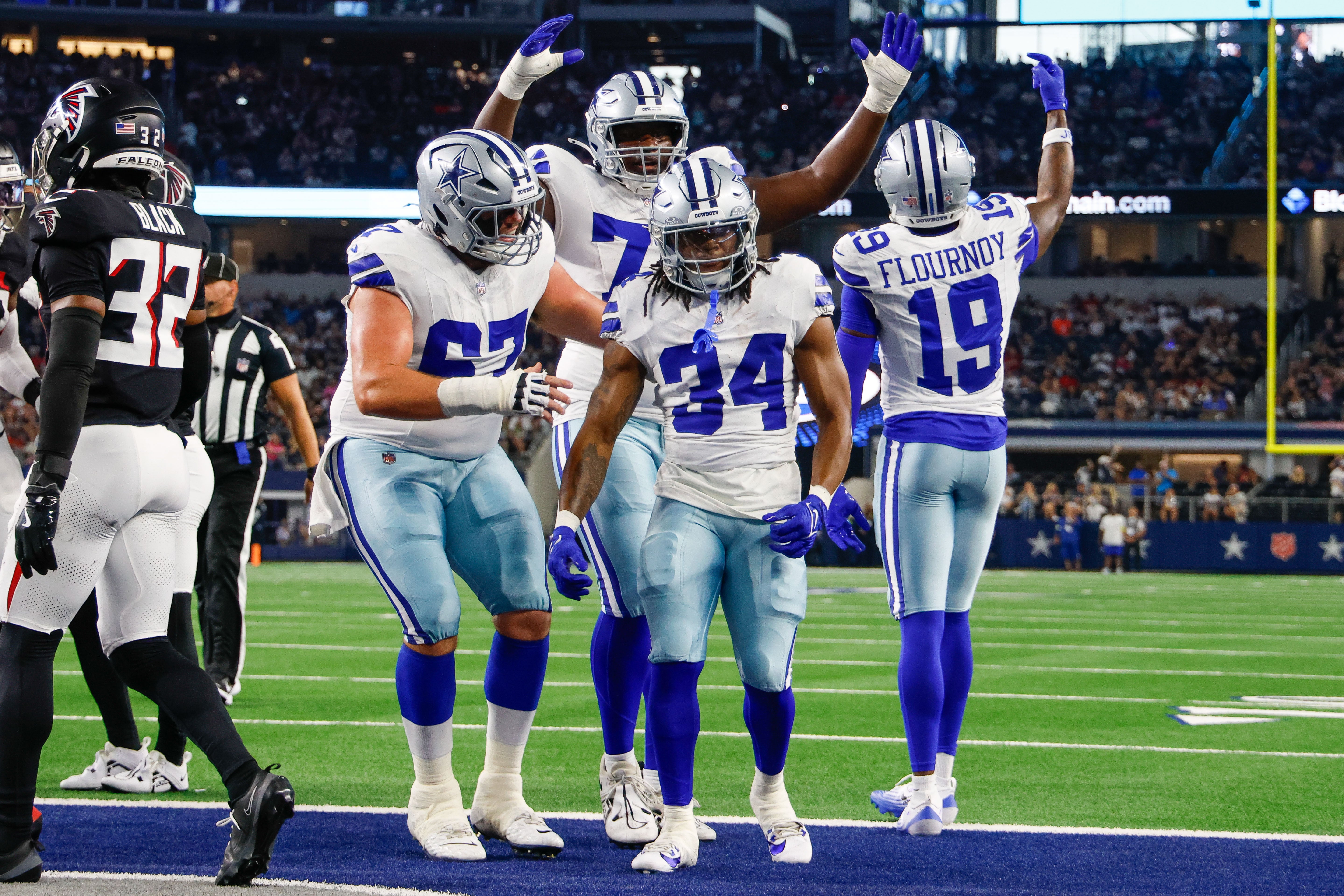 Teammates celebrate with Dallas Cowboys running back Jaydon Blue (34) after he scores a touchdown against the Atlanta Falcons during the first quarter at AT&T Stadium.