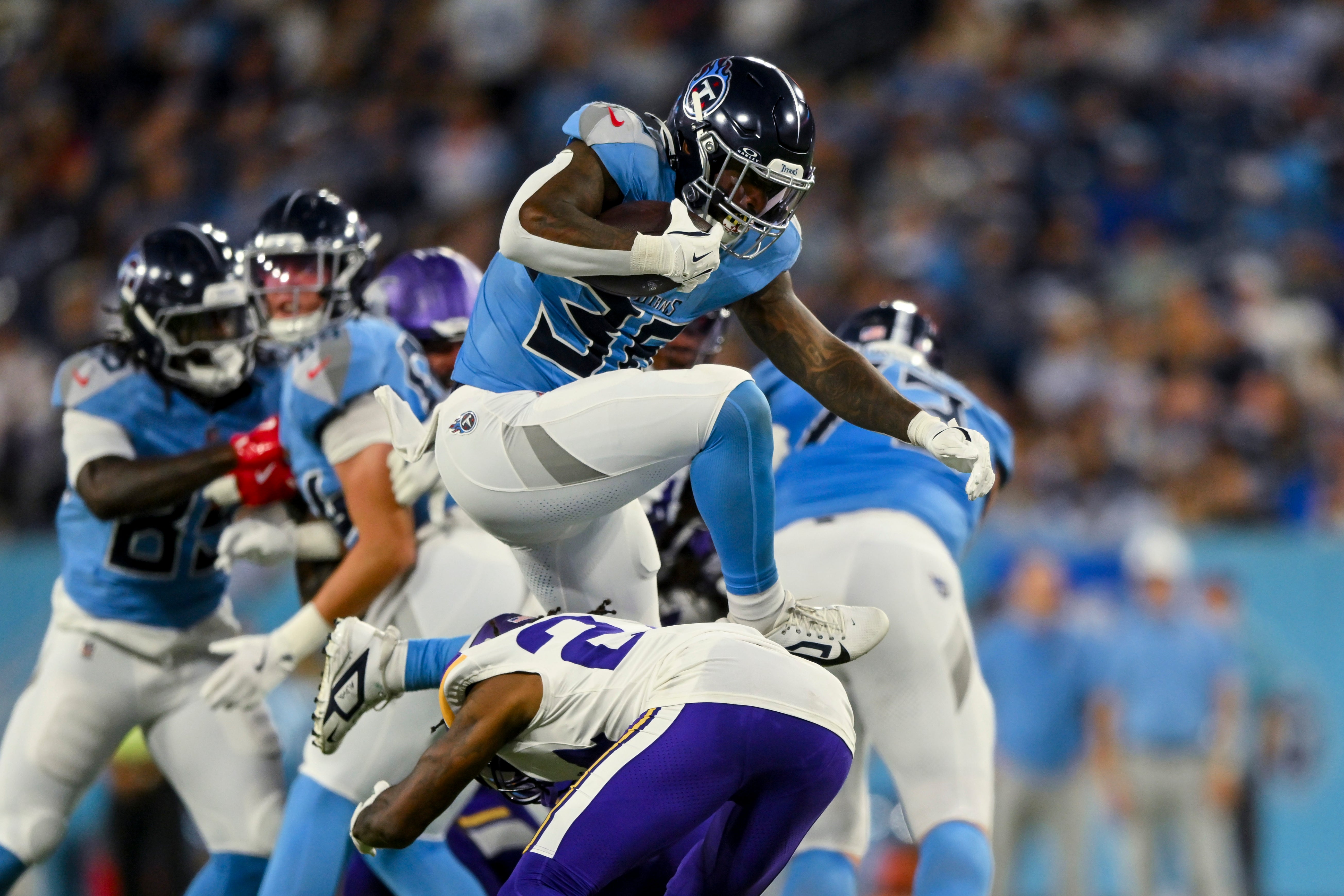 Aug 22, 2025; Nashville, Tennessee, USA; Tennessee Titans cornerback Jalen Kimber (35) hurdles Minnesota Vikings linebacker Cam Gill (28) during the first half at Nissan Stadium.