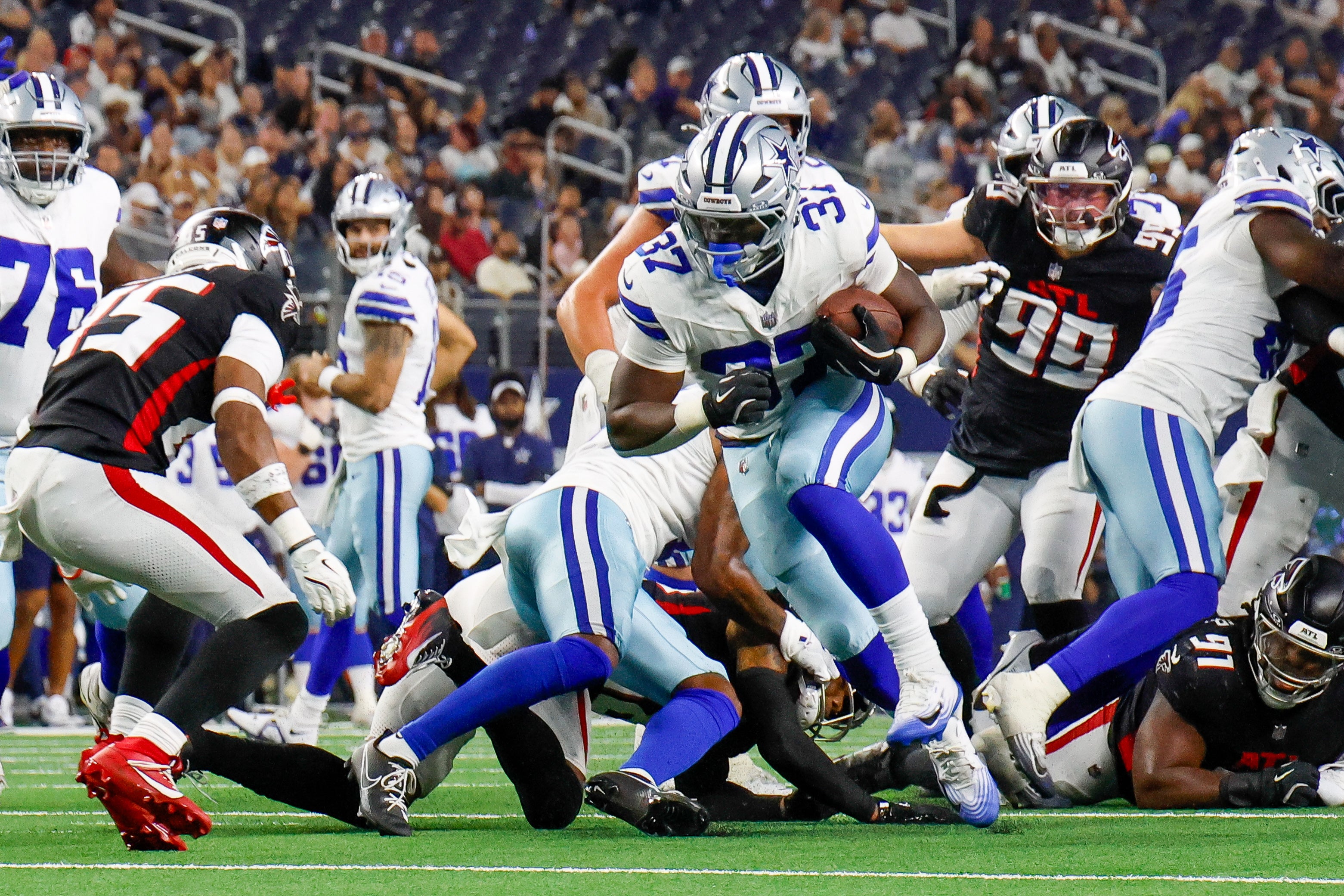 Dallas Cowboys running back Phil Mafah (37) breaks through the line during the fourth quarter against the Atlanta Falcons at AT&T Stadium.