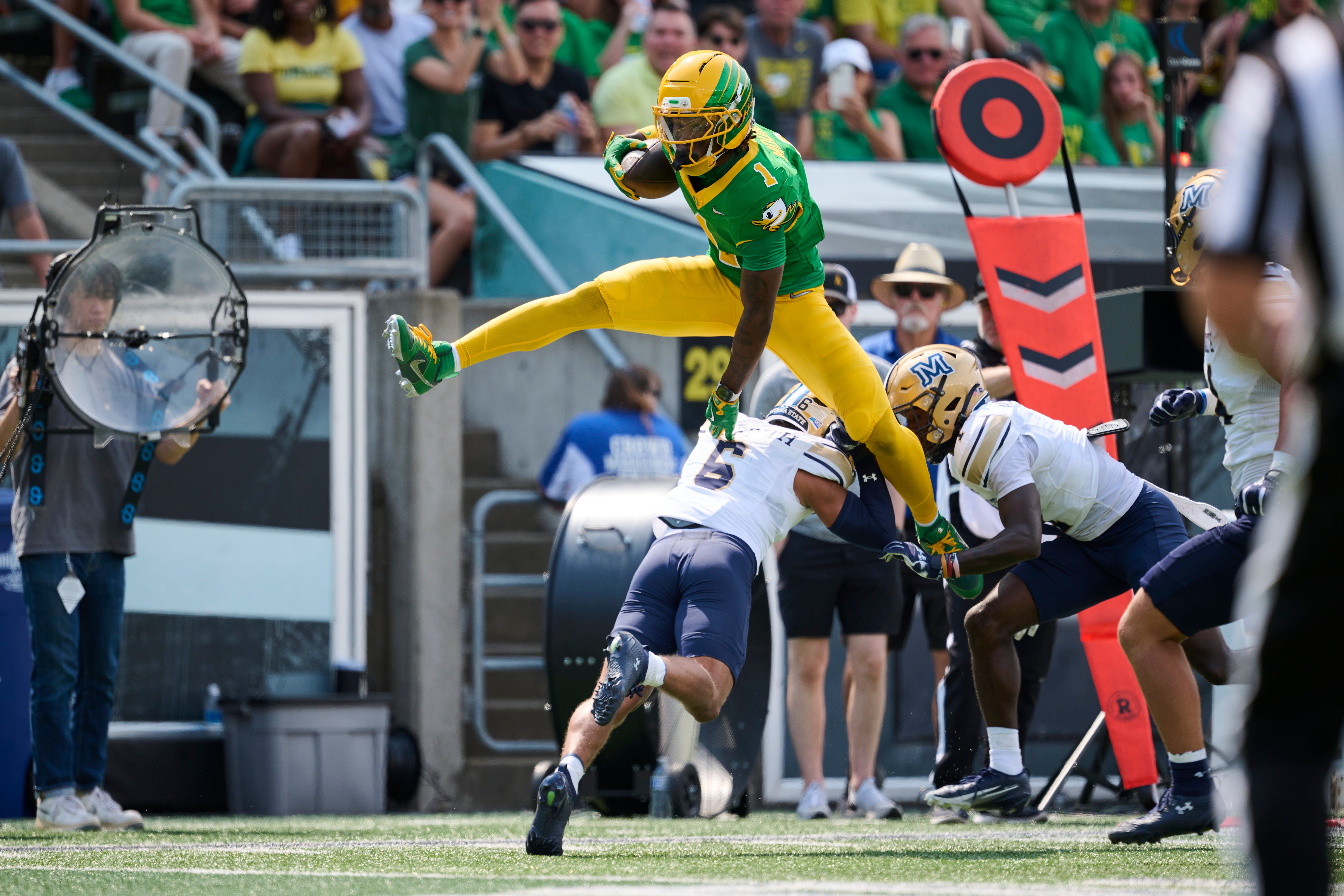 Aug 30, 2025; Eugene, Oregon, USA; Oregon Ducks wide receiver Dakorien Moore (1) leaps over Montana State Bobcats defensive back Bryant Meredith (6) during the first half at Autzen Stadium. Mandatory Credit: Troy Wayrynen-Imagn Images