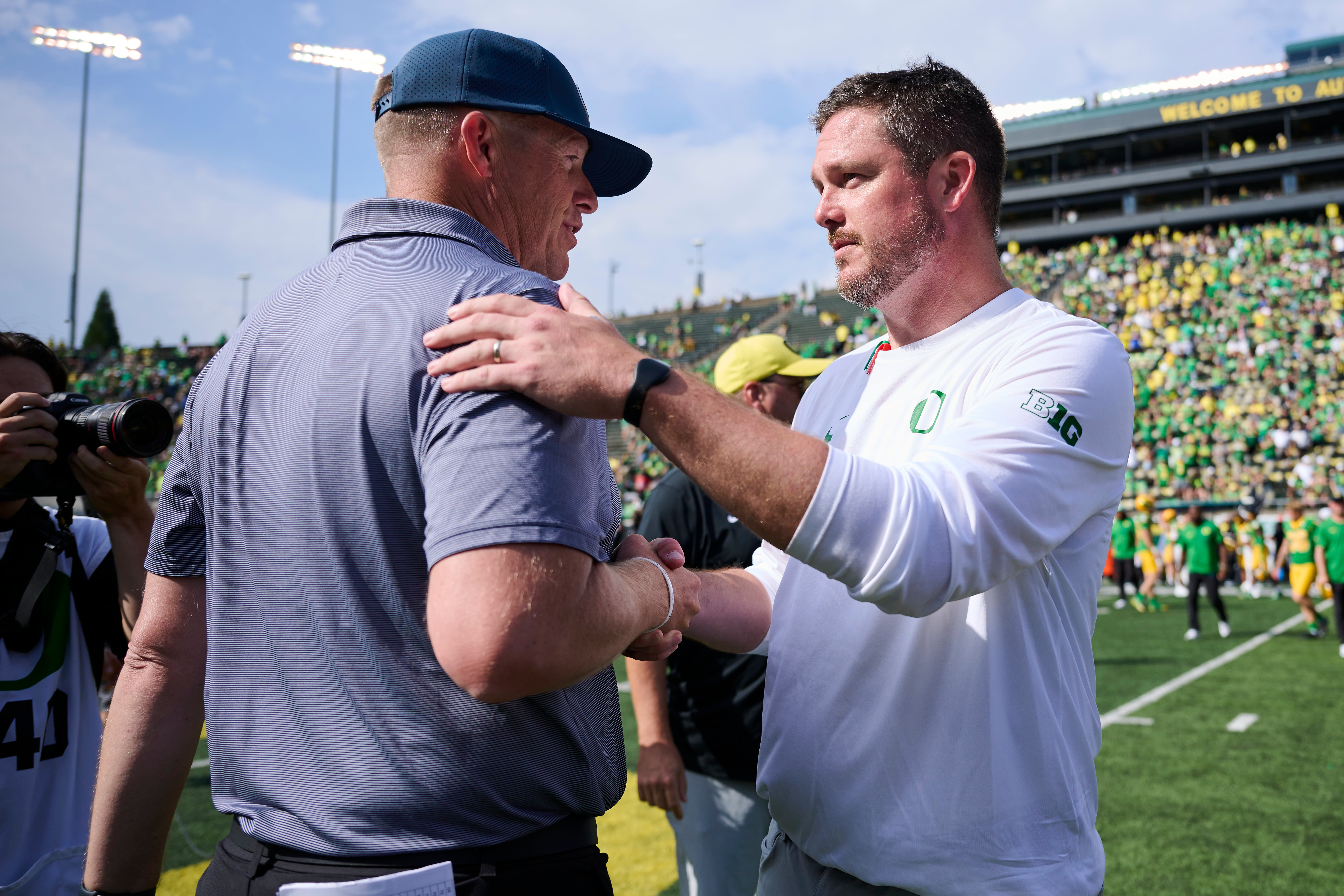 Aug 30, 2025; Eugene, Oregon, USA; Oregon Ducks head coach Dan Lanning, right, and Montana State Bobcats head coach Brent Vigen shake hands after a game at Autzen Stadium. Mandatory Credit: Troy Wayrynen-Imagn Images