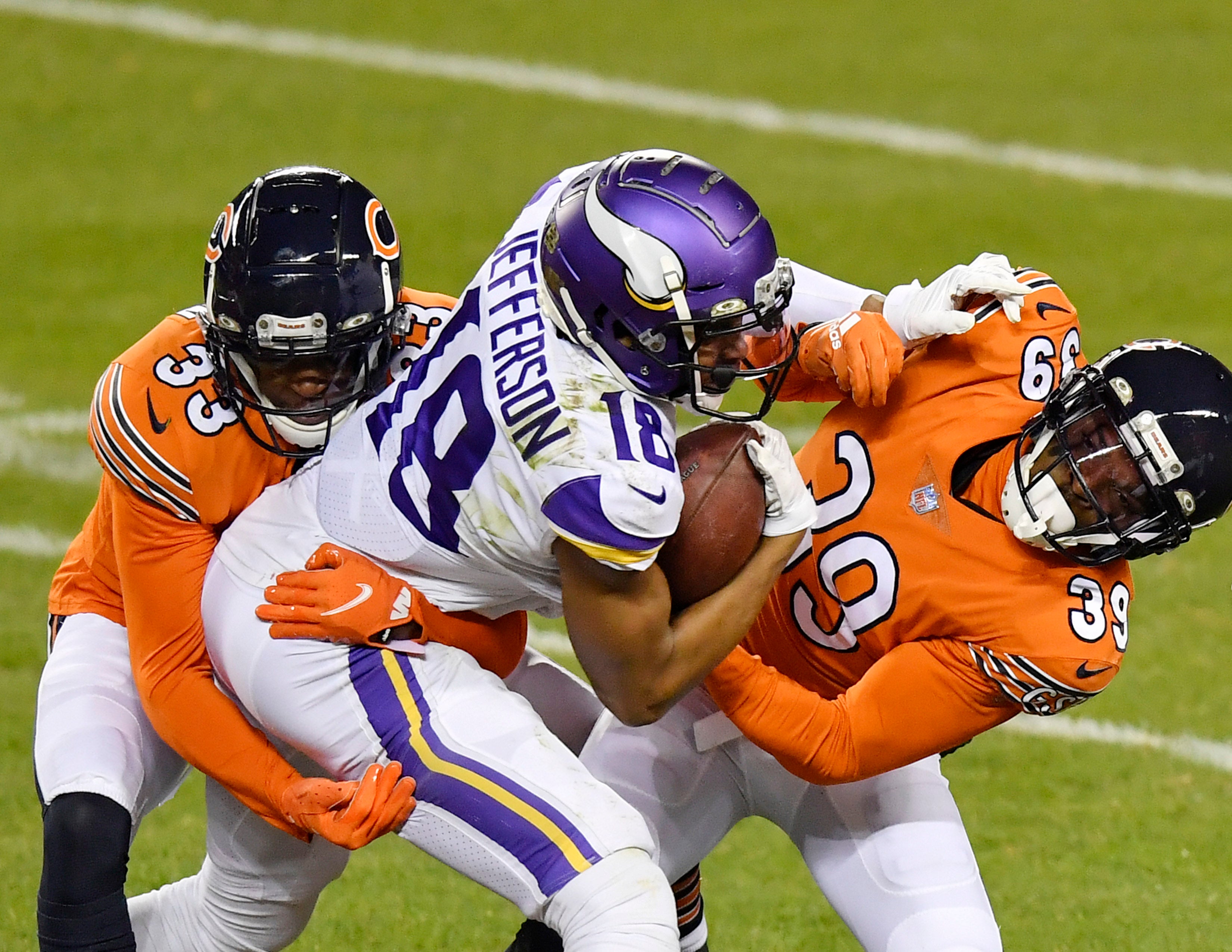 Nov 16, 2020; Chicago, Illinois, USA; Minnesota Vikings wide receiver Justin Jefferson (18) is tackled in the first half by Chicago Bears free safety Eddie Jackson (39) and Chicago Bears cornerback Jaylon Johnson (33) at Soldier Field.