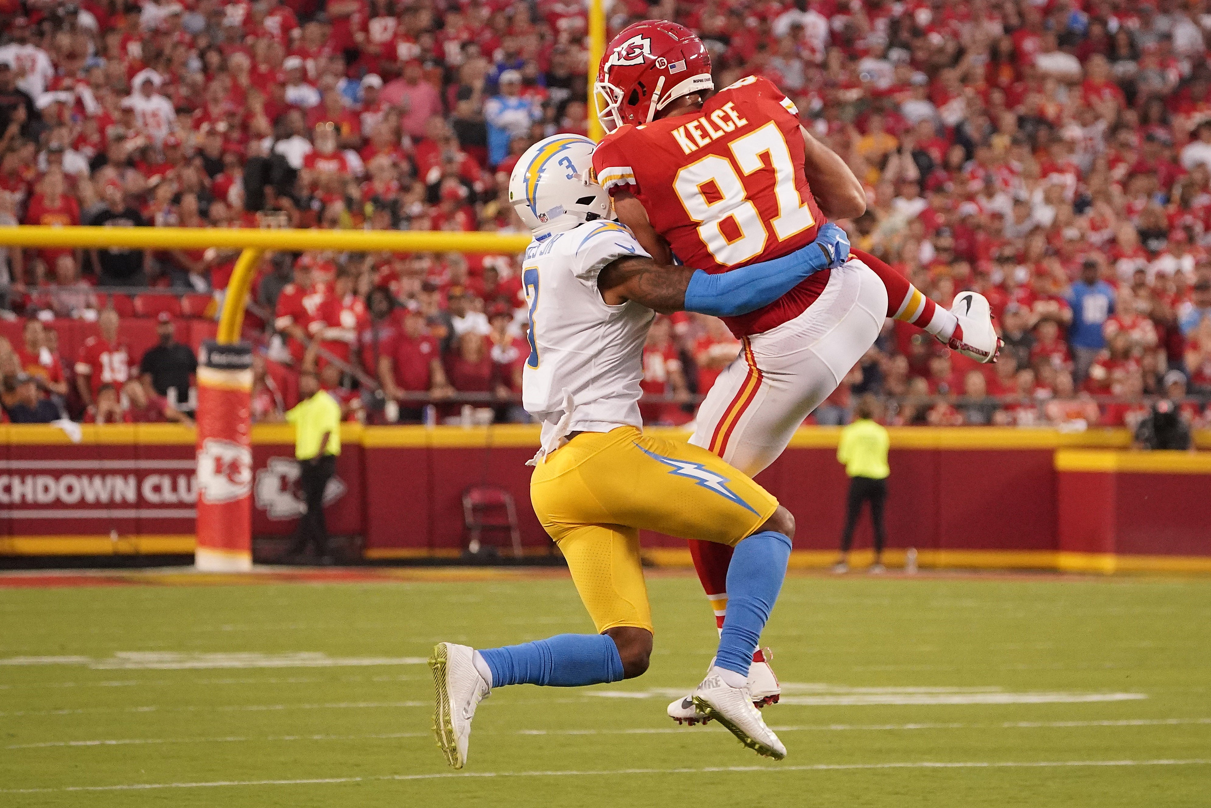 Kansas City Chiefs tight end Travis Kelce (87) catches a pass against Los Angeles Chargers safety Derwin James Jr. (3) during the first half at GEHA Field at Arrowhead Stadium.
