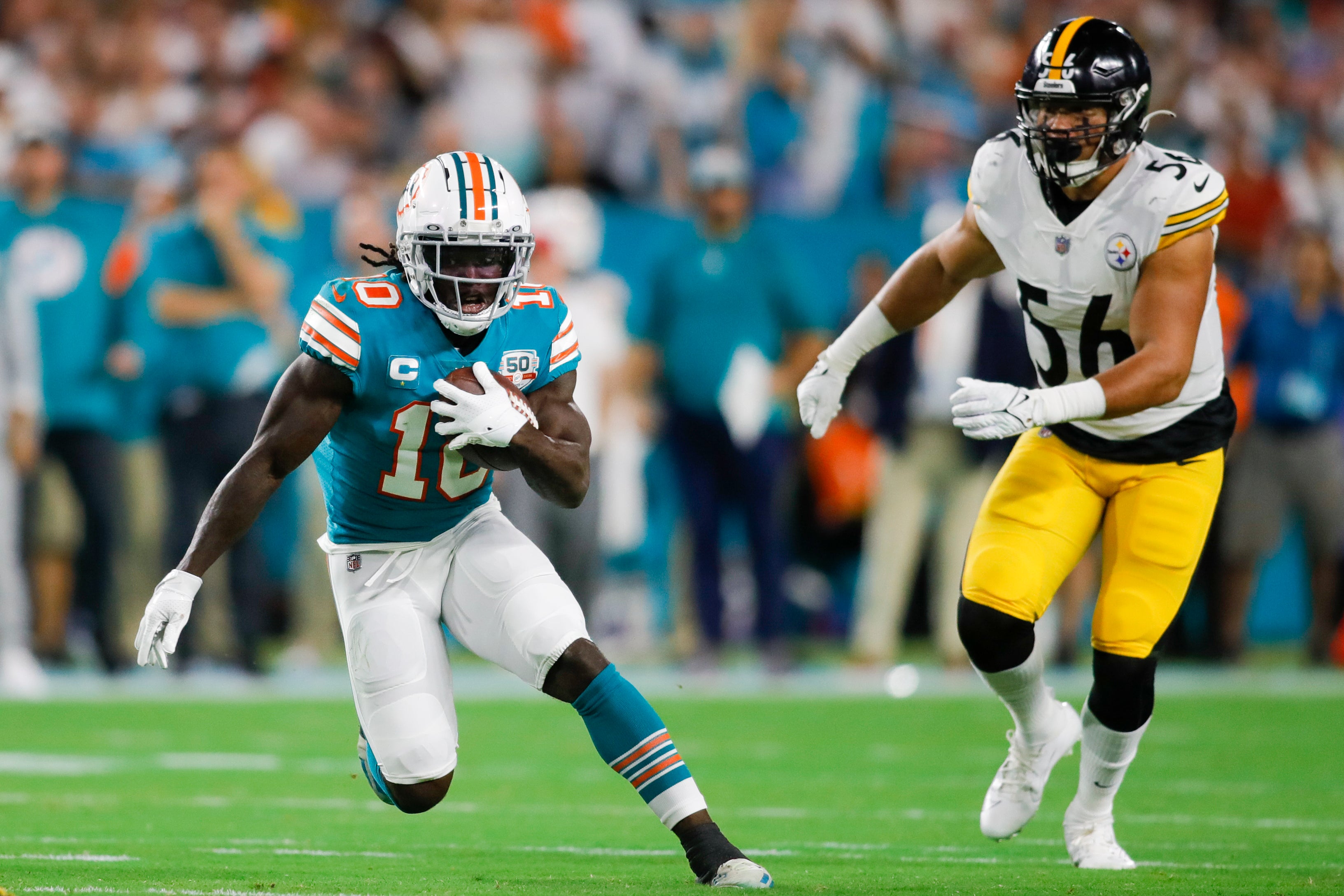 Oct 23, 2022; Miami Gardens, Florida, USA; Miami Dolphins wide receiver Tyreek Hill (10) runs with the football ahead of Pittsburgh Steelers linebacker Alex Highsmith (56) during the first quarter at Hard Rock Stadium.