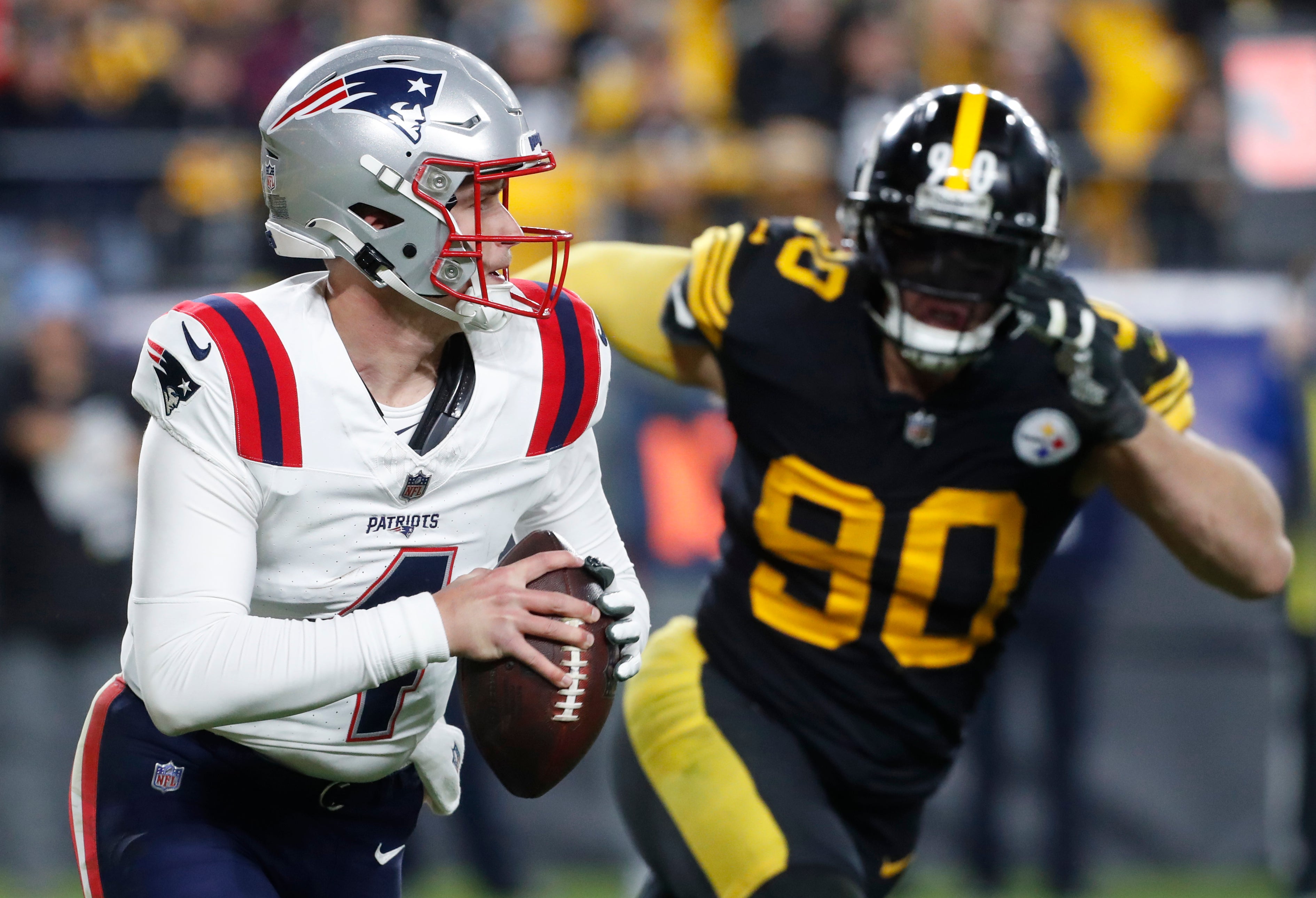 Dec 7, 2023; Pittsburgh, Pennsylvania, USA; New England Patriots quarterback Bailey Zappe (4) runs the ball as Pittsburgh Steelers linebacker T.J. Watt (90) chases during the third quarter at Acrisure Stadium. New England won 21-18.