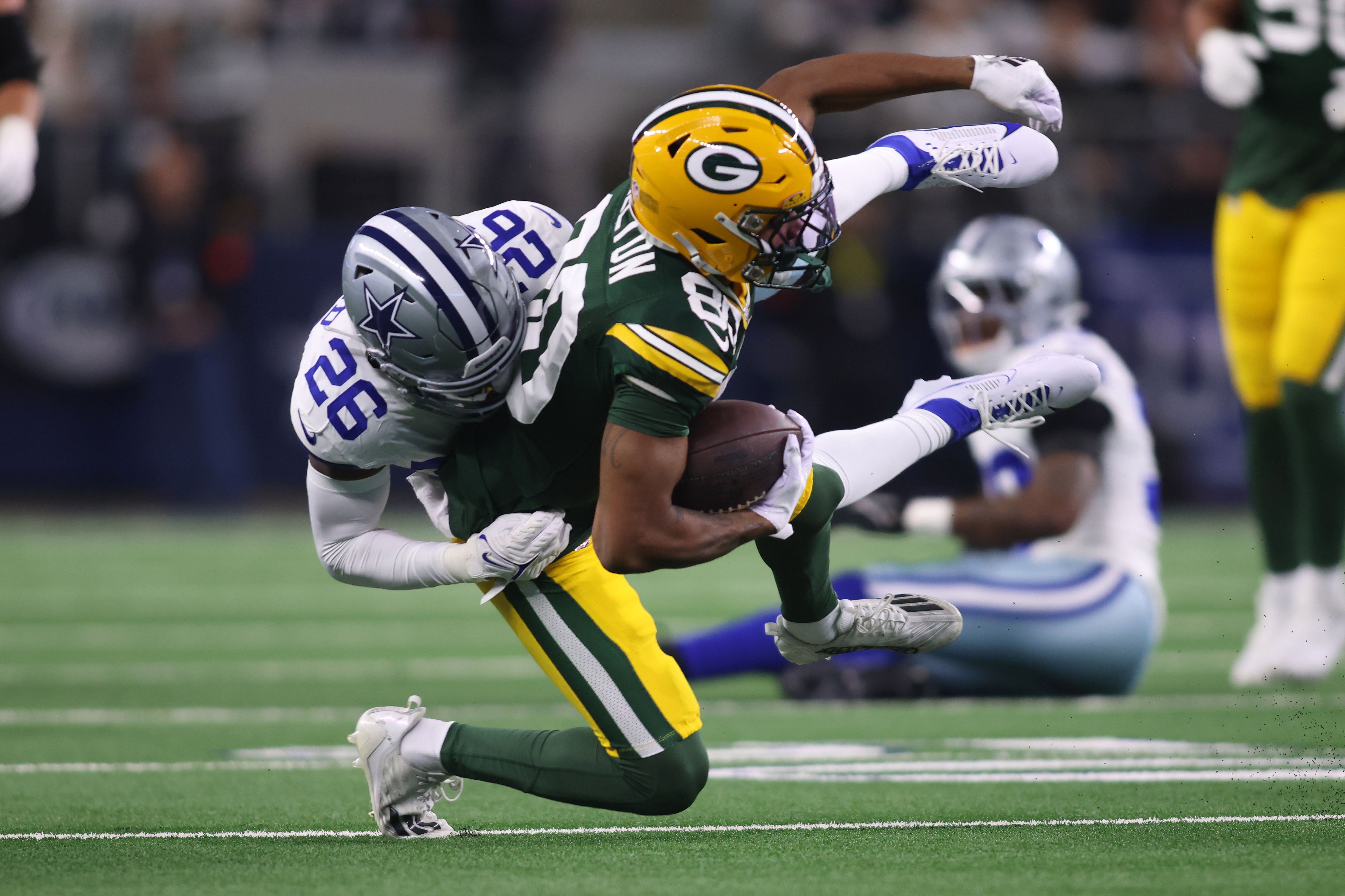 Green Bay Packers wide receiver Bo Melton (80) makes a catch against Dallas Cowboys cornerback DaRon Bland (26) in the first quarter for the 2024 NFC wild card game at AT&T Stadium.