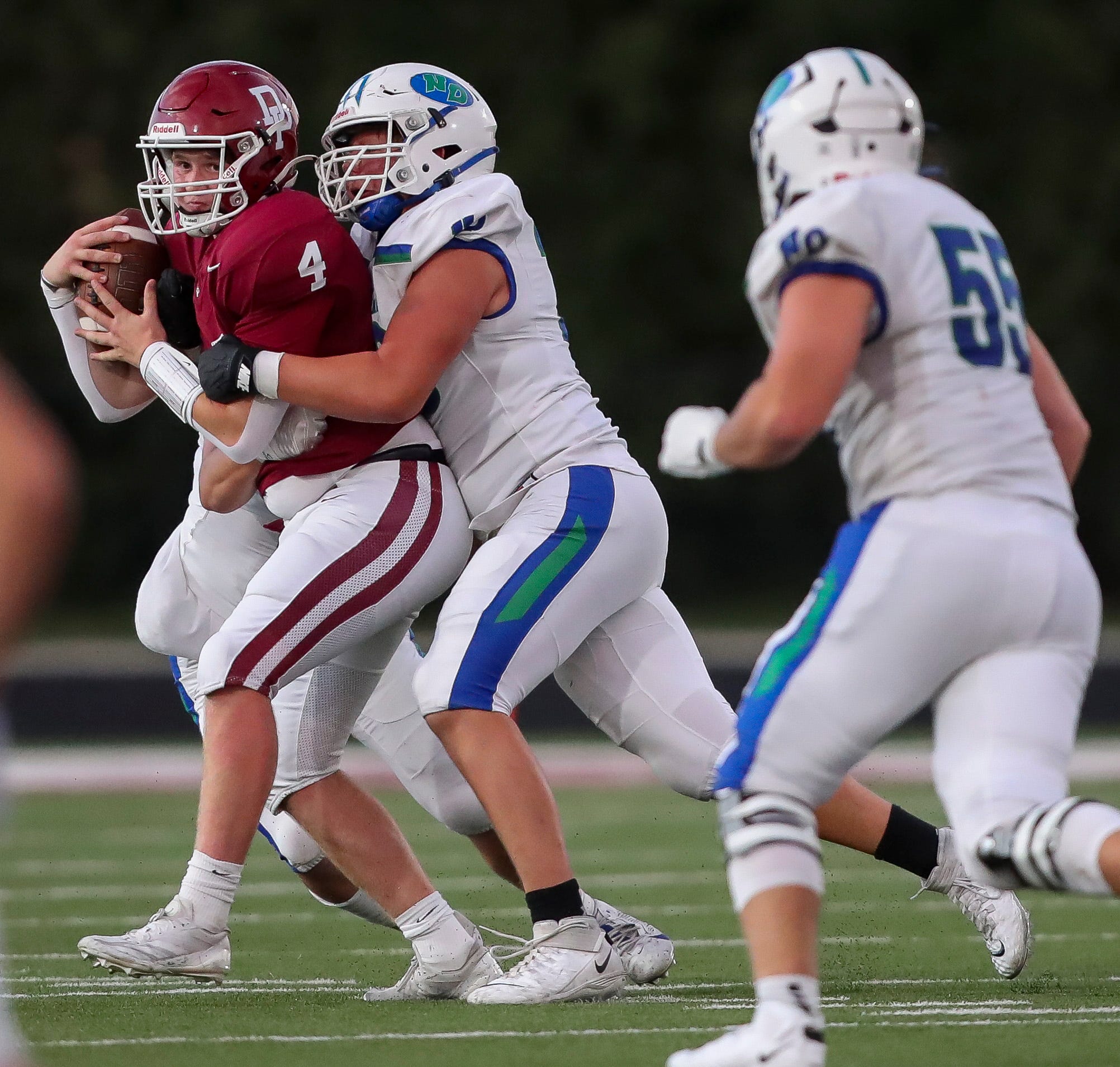 Notre Dame Academy's Richie Flanigan (76) sacks De Pere High School's Marcus Schmidt (4) on Friday, August 30, 2024, at De Pere High School in De Pere, Wis. Notre Dame won the game, 7-3.