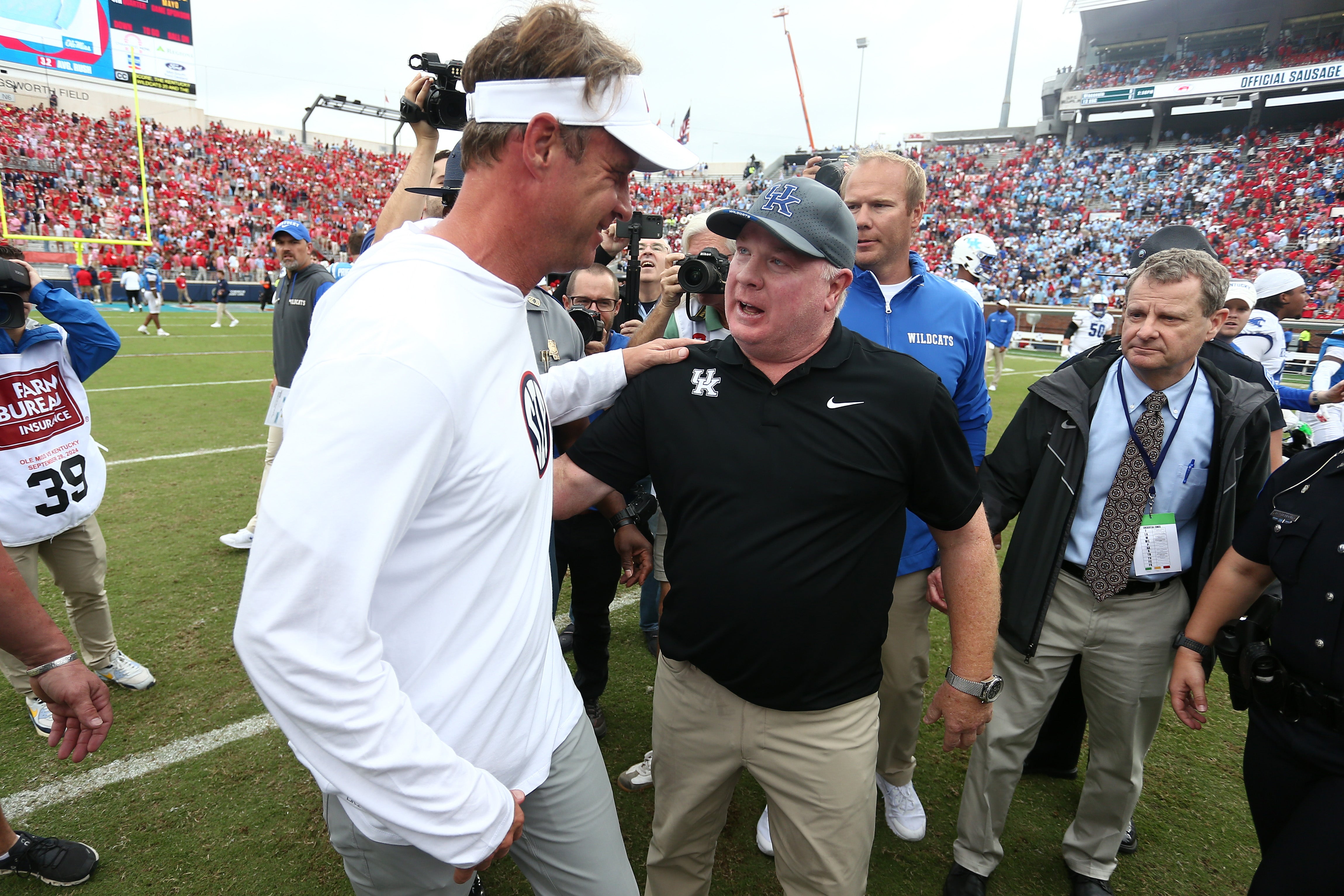 Sep 28, 2024; Oxford, Mississippi, USA; Mississippi Rebels head coach Lane Kiffin (left) and Kentucky Wildcats head coach Mark Stoops (right) embrace after the game at Vaught-Hemingway Stadium.