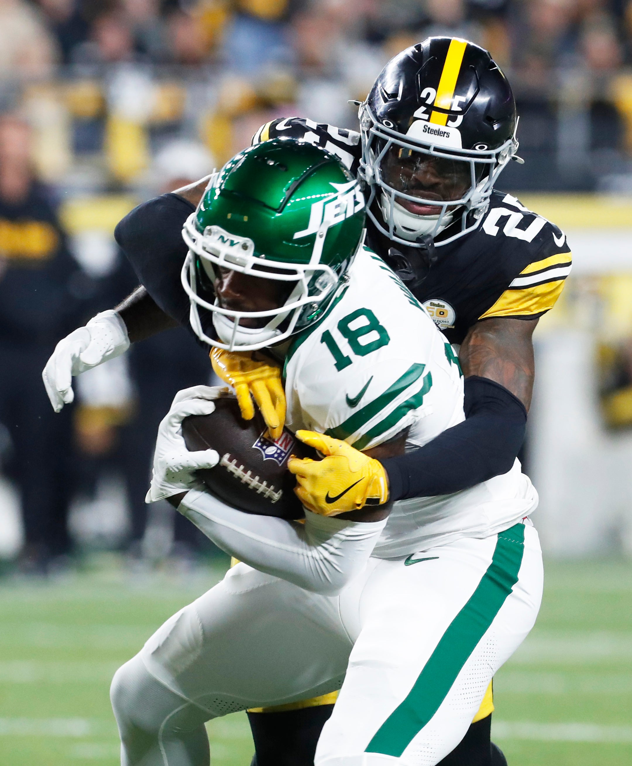 Oct 20, 2024; Pittsburgh, Pennsylvania, USA; Pittsburgh Steelers safety DeShon Elliott (25) tackles New York Jets wide receiver Mike Williams (18) after a catch during the third quarter against at Acrisure Stadium.