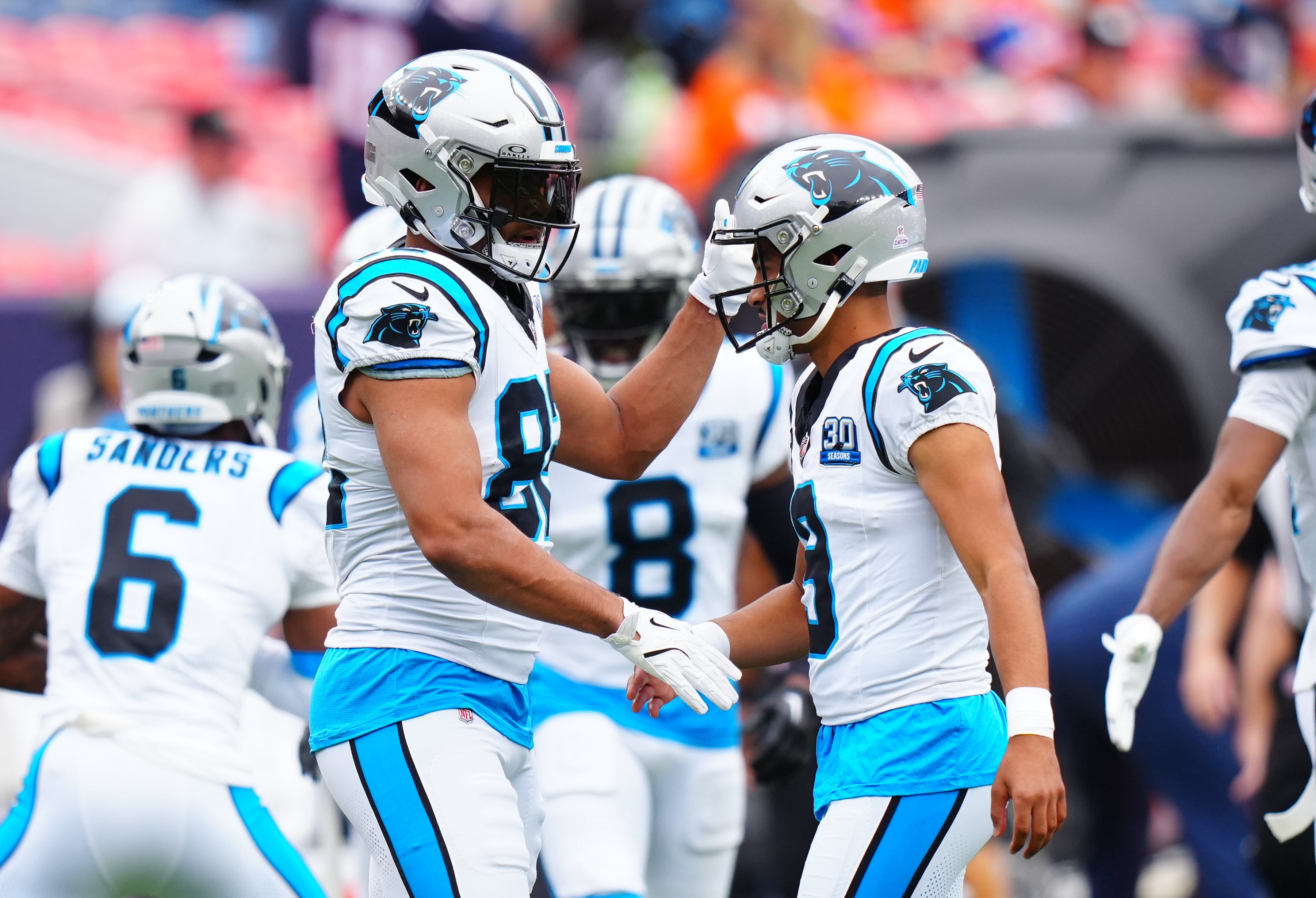 Oct 27, 2024; Denver, Colorado, USA; Carolina Panthers quarterback Bryce Young (right) greets tight end Tommy Tremble (82) before the game against the Denver Broncos at Empower Field at Mile High.