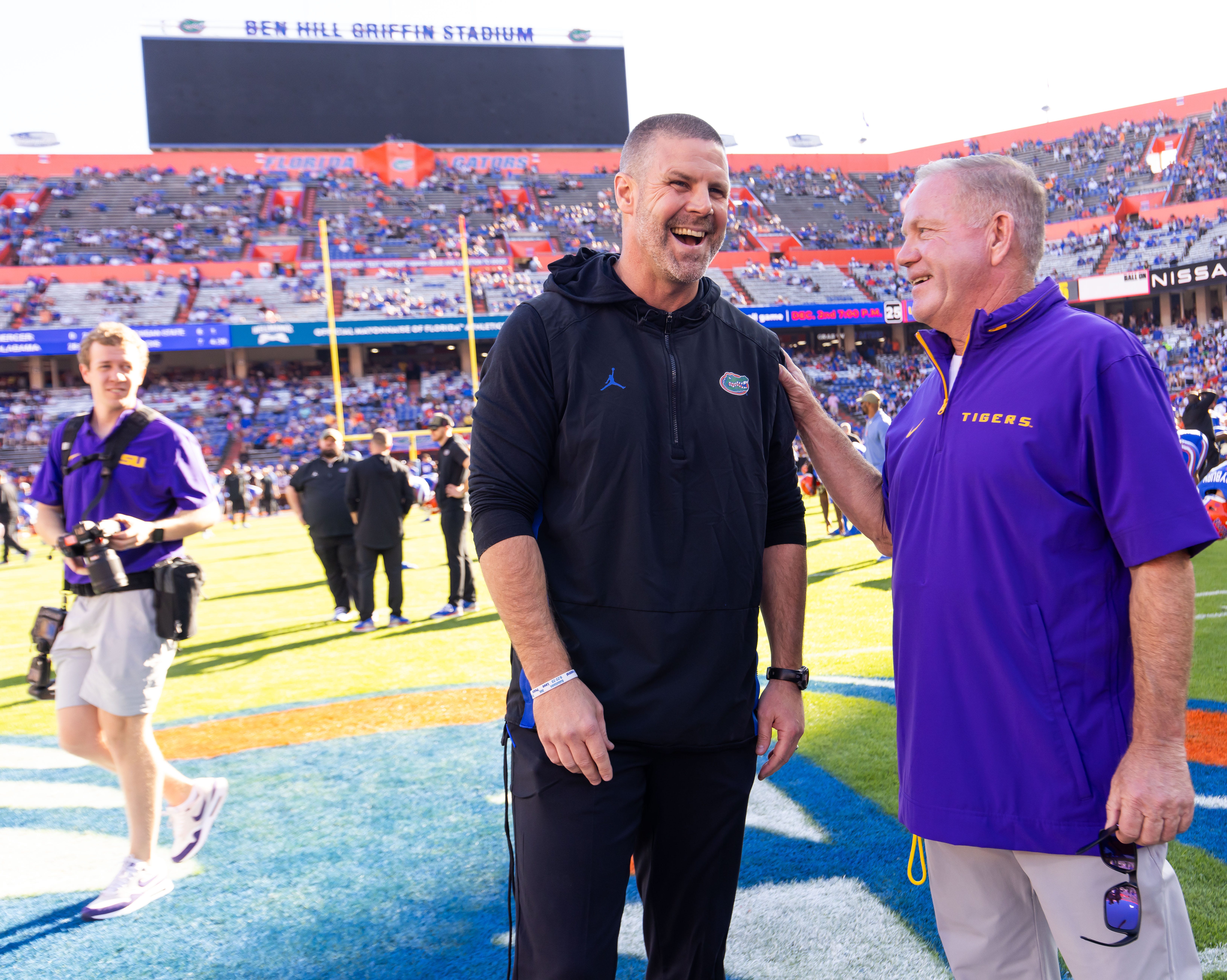 Florida Gators head coach Billy Napier and LSU Tigers head coach Brian Kelly have a laugh before the start of the game at midfield during warm ups at Ben Hill Griffin Stadium in Gainesville, FL on Saturday, November 16, 2024.