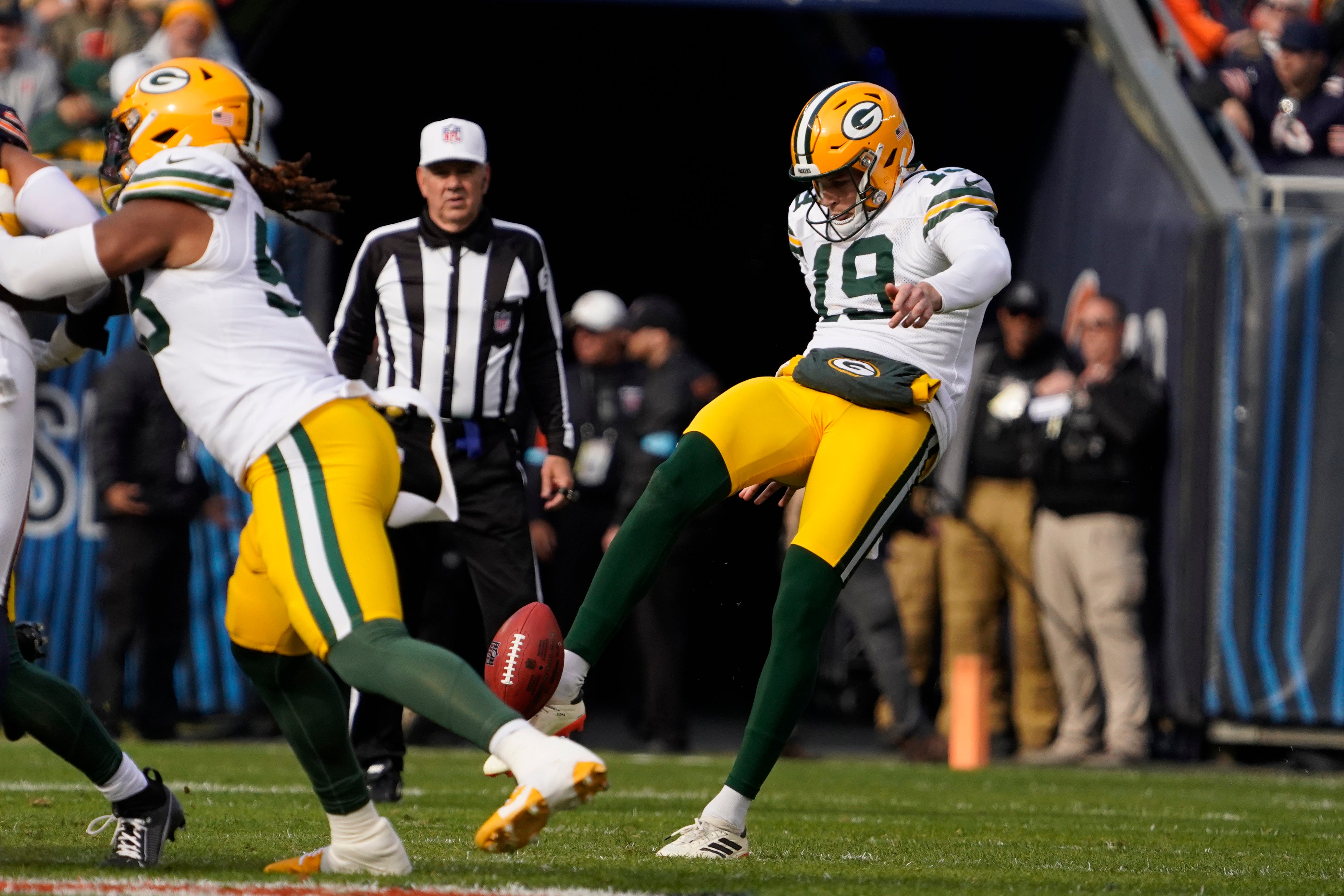 Nov 17, 2024; Chicago, Illinois, USA; Green Bay Packers punter Daniel Whelan (19) punts against the Chicago Bears during the first half at Soldier Field.