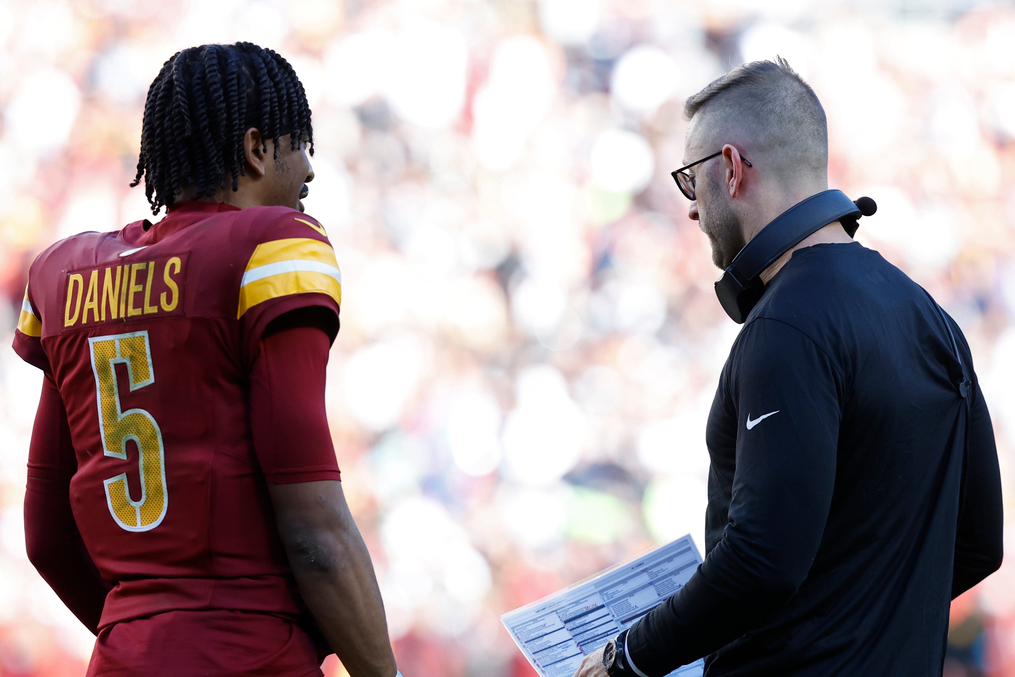 Nov 24, 2024; Landover, Maryland, USA; Washington Commanders quarterback Jayden Daniels (5) talks with Commanders offensive coordinator Kliff Kingsbury (R) during a timeout Dallas Cowboys during the second quarter at Northwest Stadium.